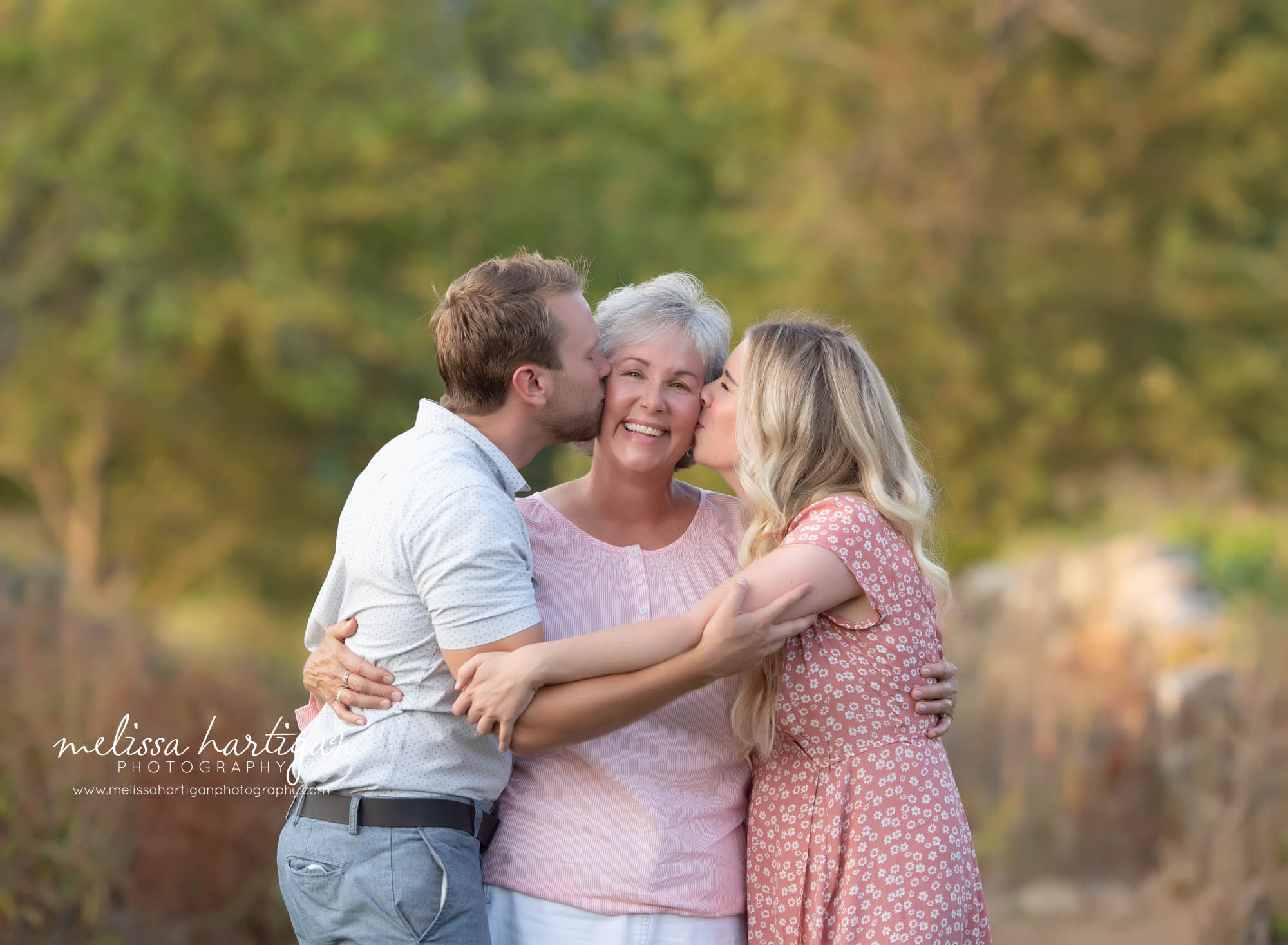 adult kids giving mom a kiss on the cheek