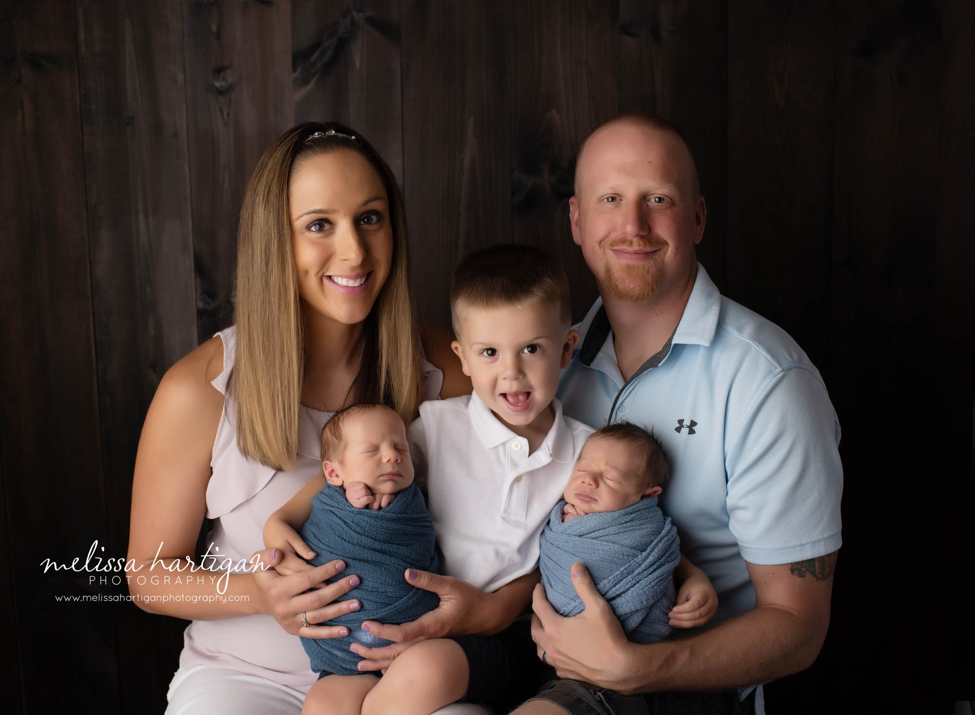 mom dad big brother and twin boys in studio newborn photography family pose