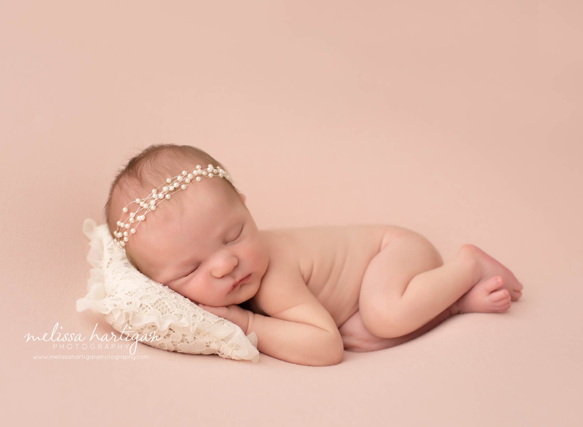 Newborn baby girl posed on lace newborn sized prop pillow with white beaded headband CT newborn Photography