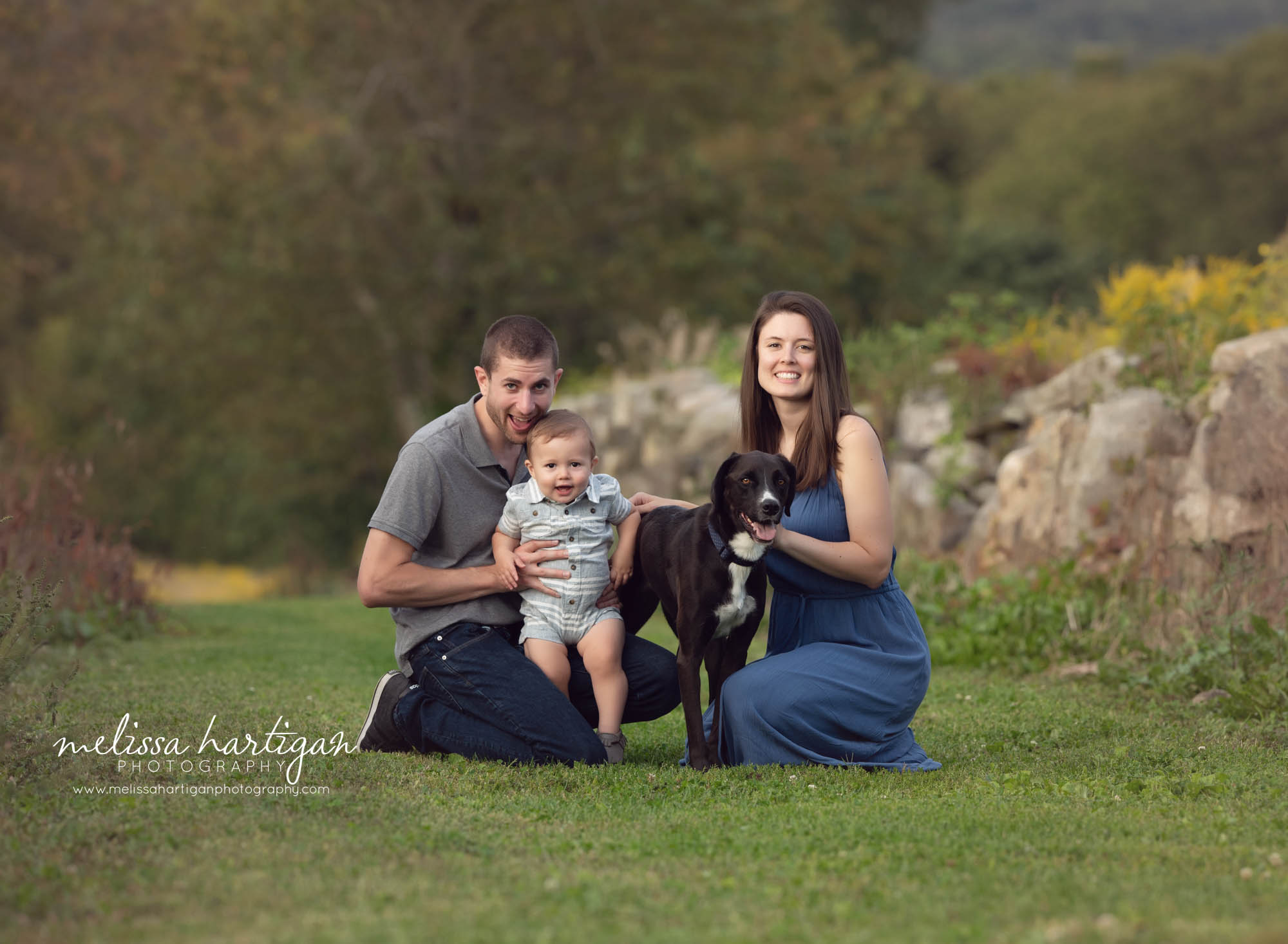 dad holding toddler son mom holding family dog family photo