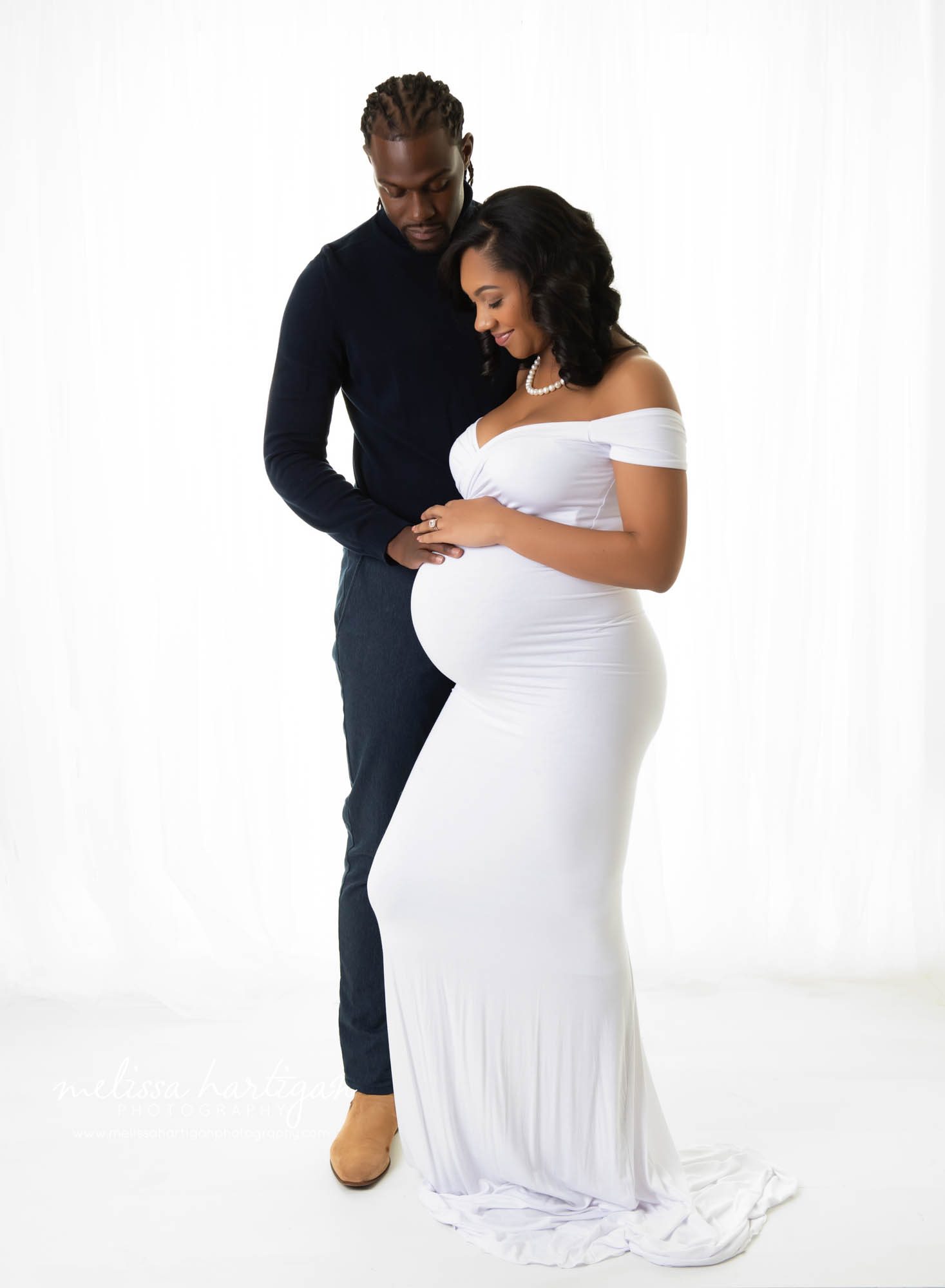 pregnant mom with dad standing studio pose holding baby bump Ct maternity photographer