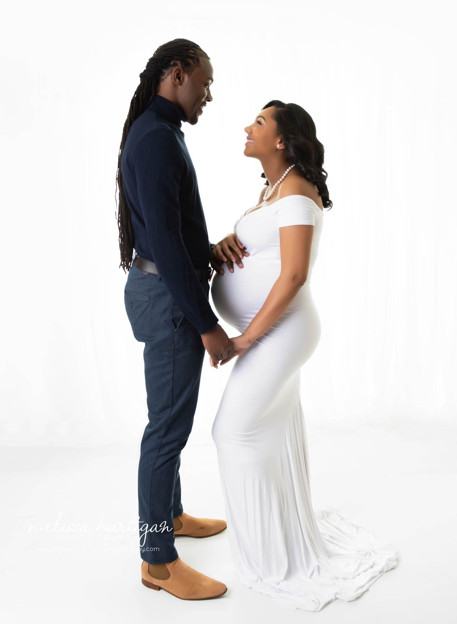 expectant couple looking at eachother studio photography