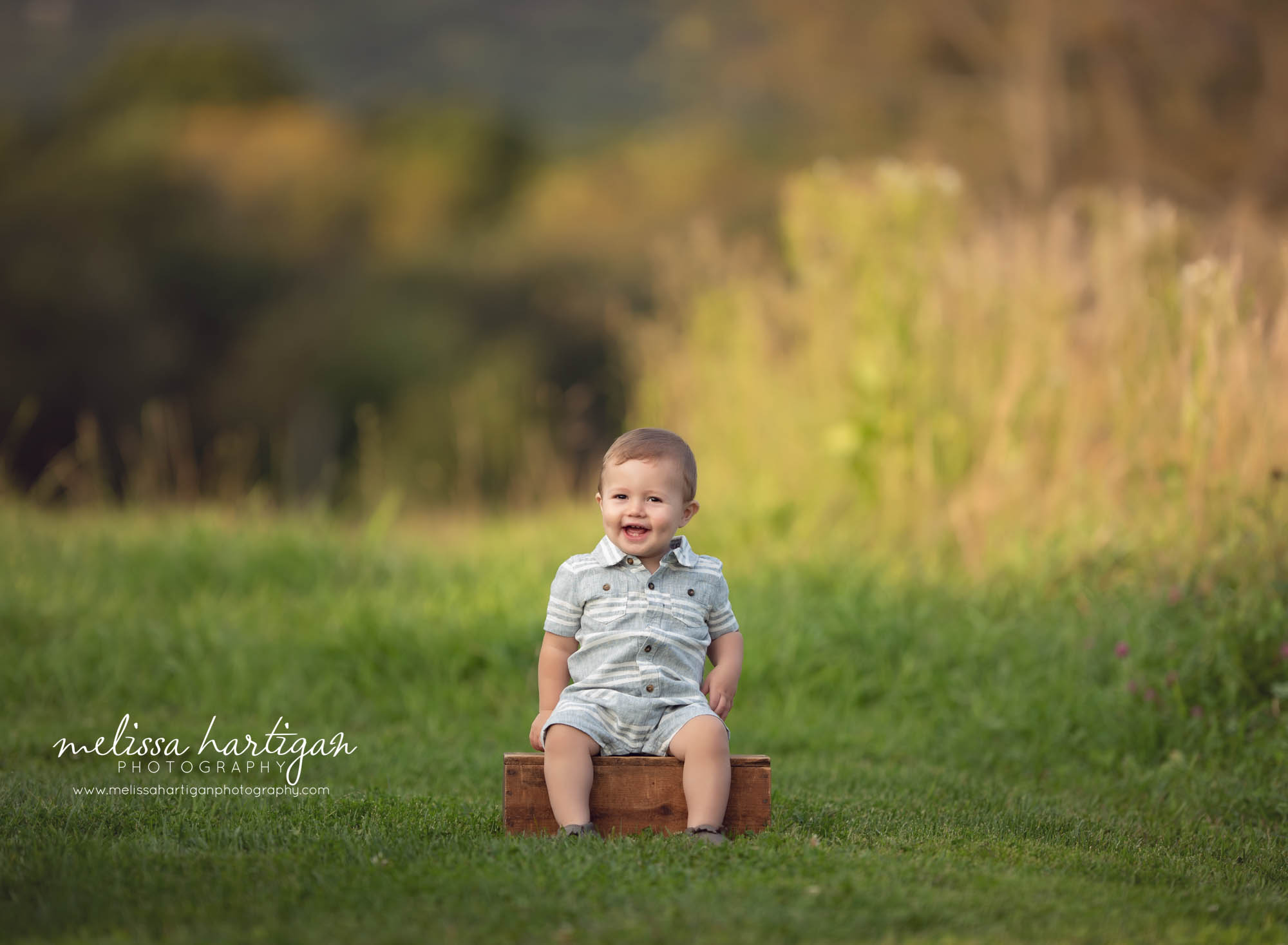 toddler boy sitton on wooden crate in Connecticut park family photographer