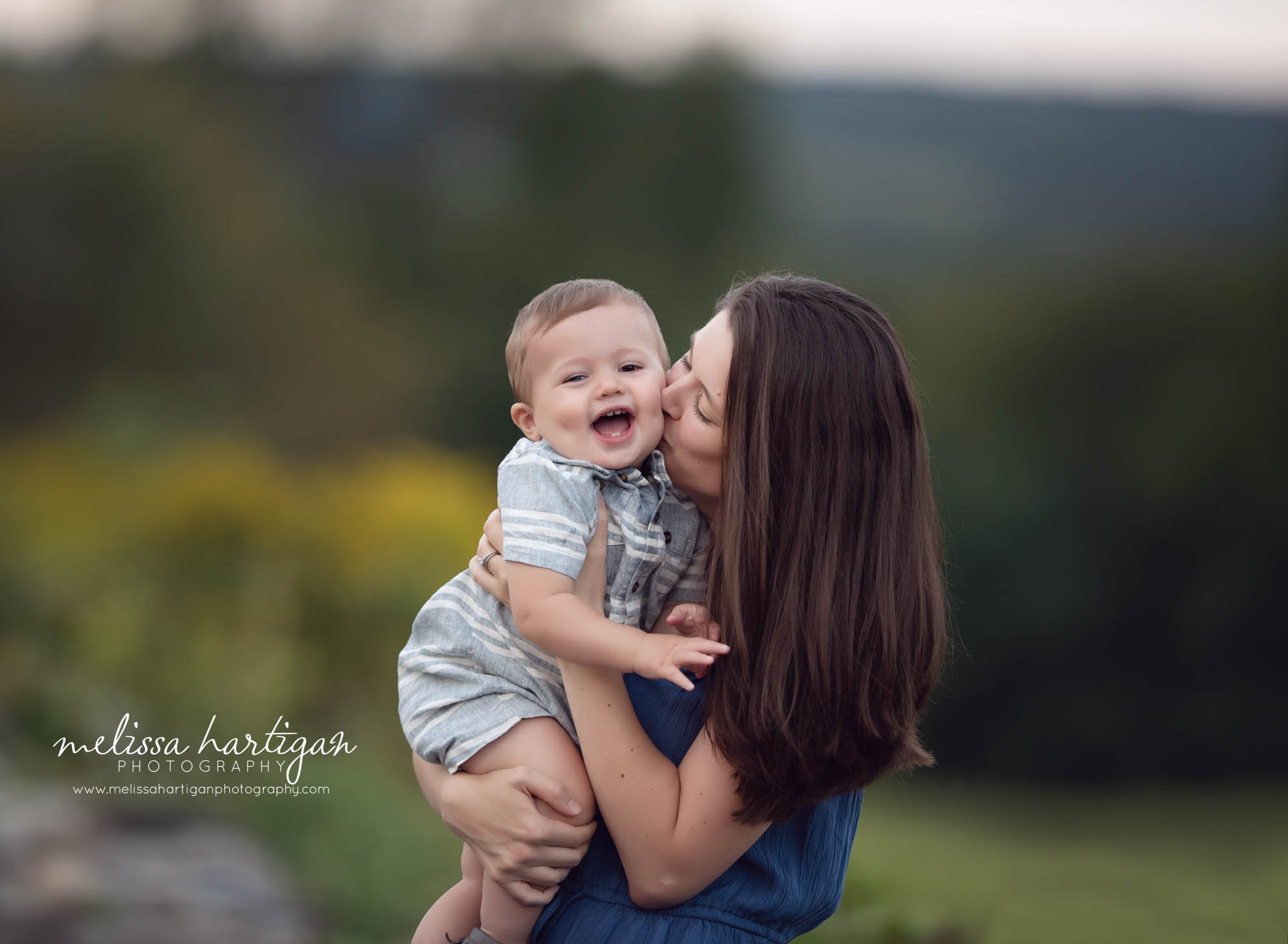 mom kissing smiling laughing toddler son on cheek Ellington Family Photographer CT