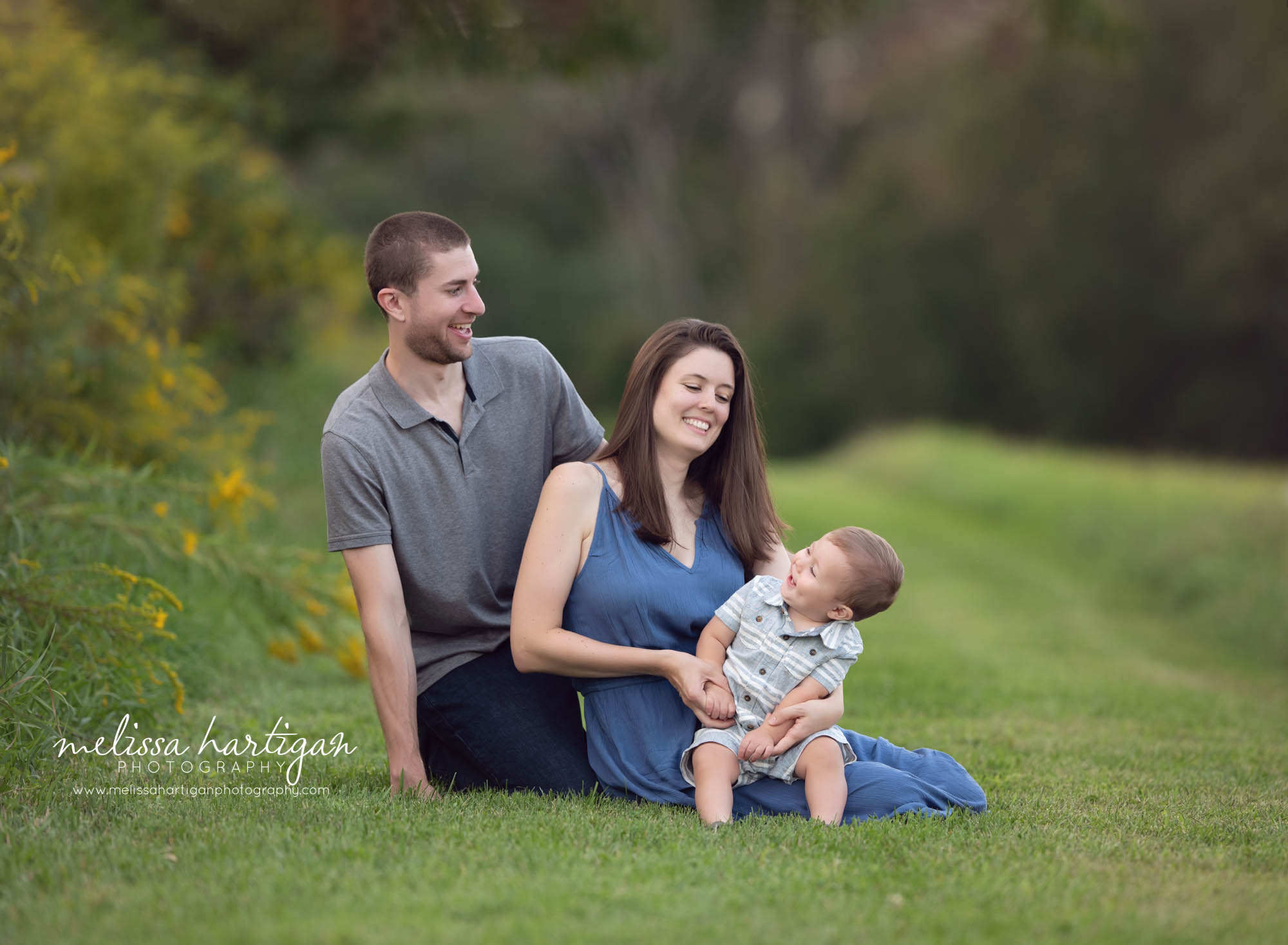 toddler boy laughing in moms lap dad behind mom making boy laugh family photographer CT