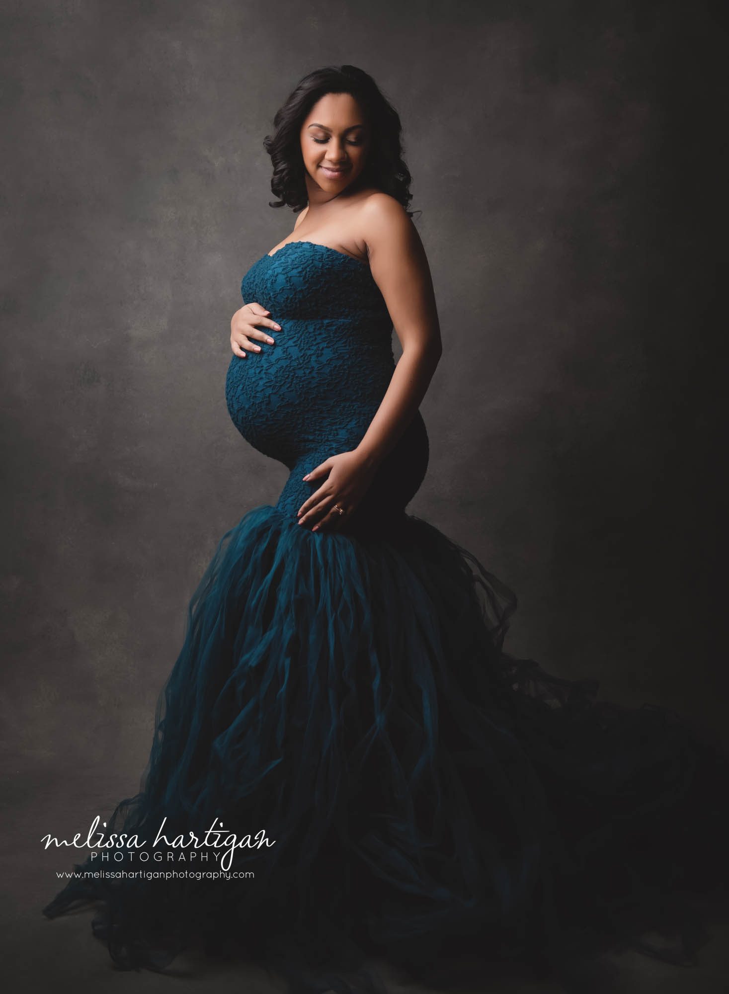 pregnant mom standing to the side holding baby bump looking down studio maternity session New Britain CT maternity Photography