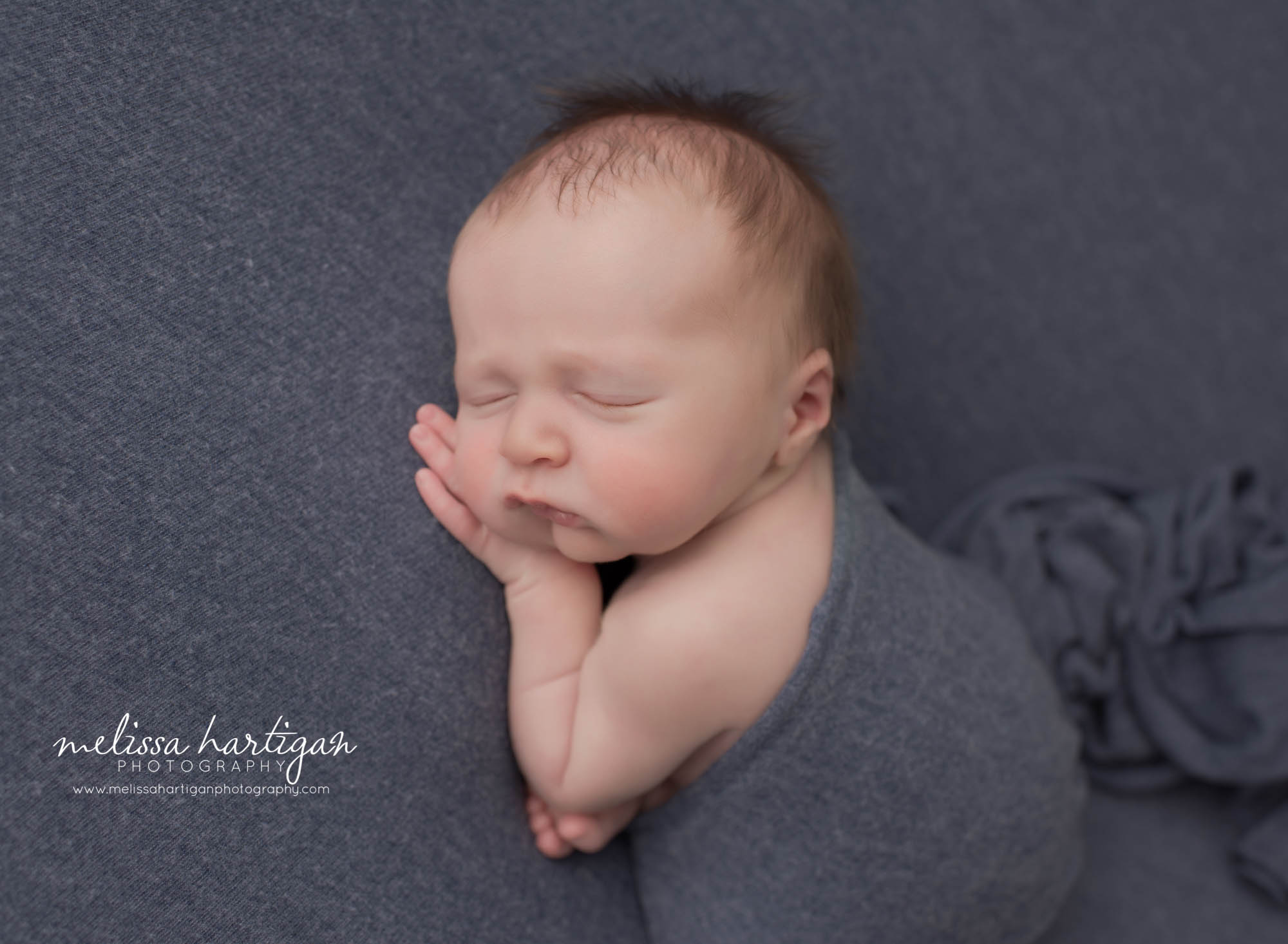 newborn baby boy posed on side taco with wrap drapped over enwborn photographer connecticut