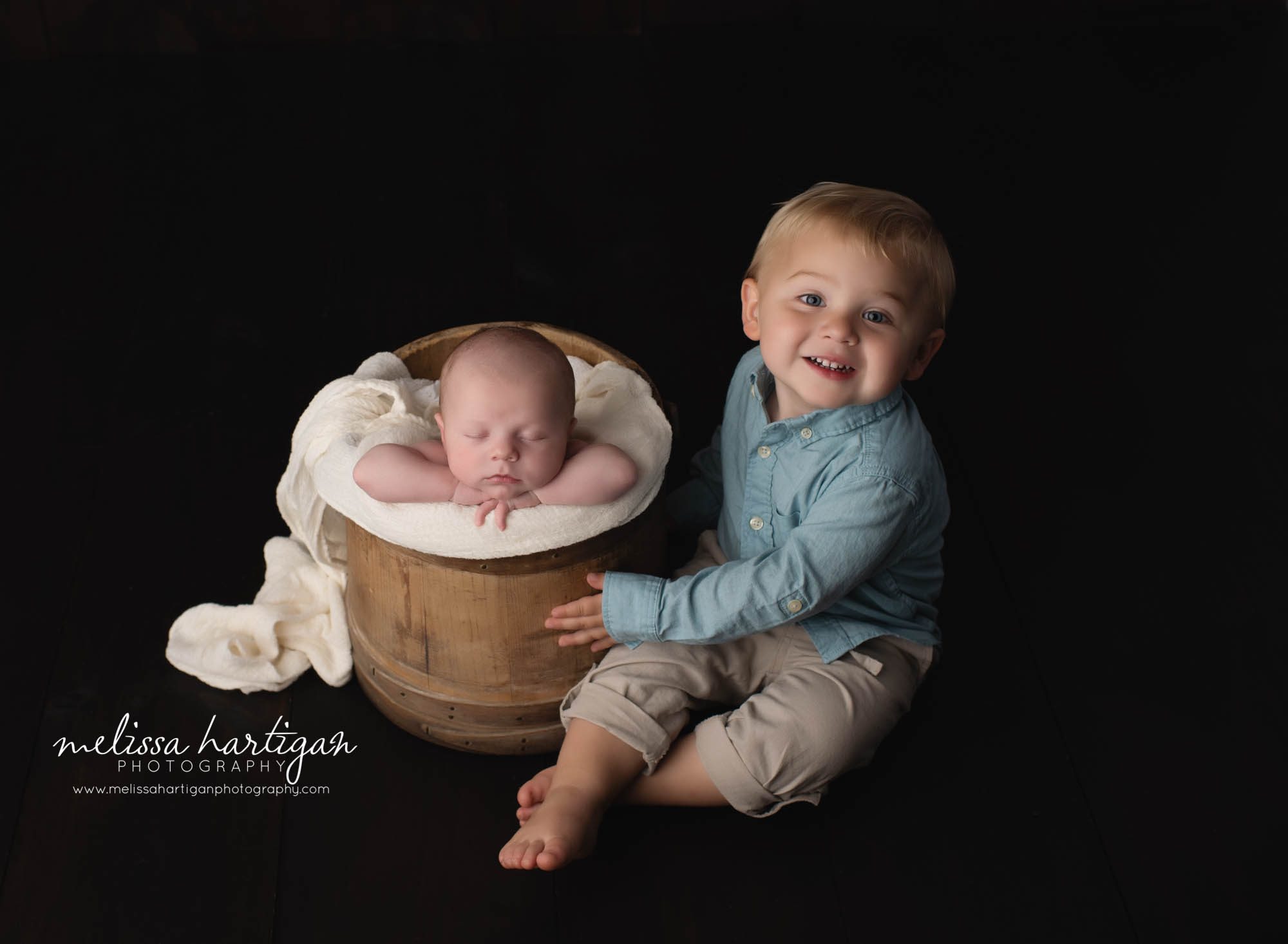 newborn and older sibling sitting next to bucket baby posed in Newborn photography CT