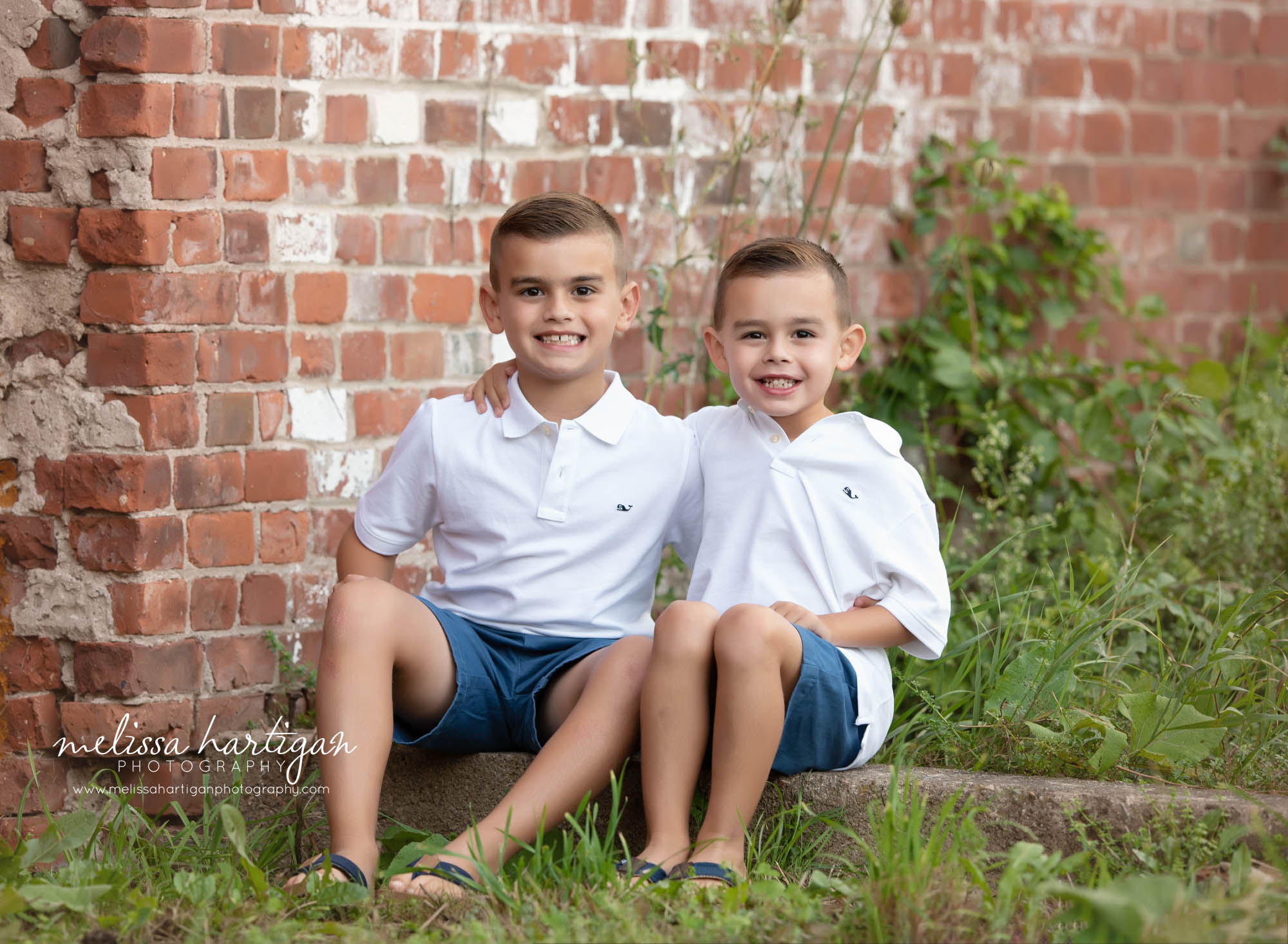 two brothers sitting down with arms around eachother smiling CT family Photography session