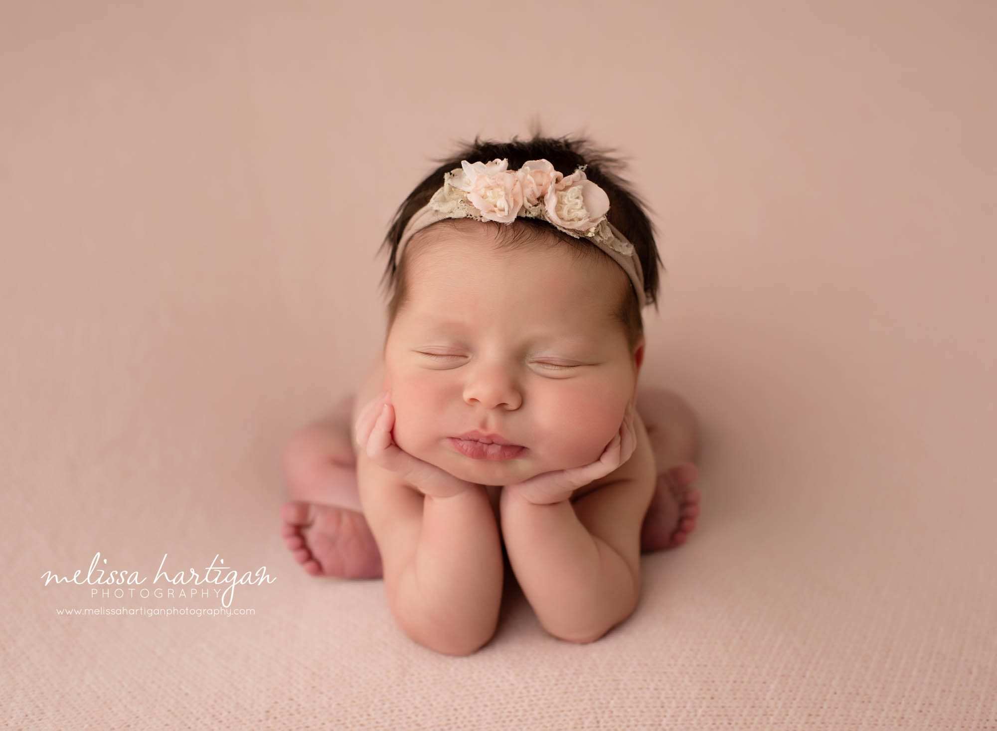 newborn baby girl posed froggy on blush pink blanket with floral headband Newborn Photography CT