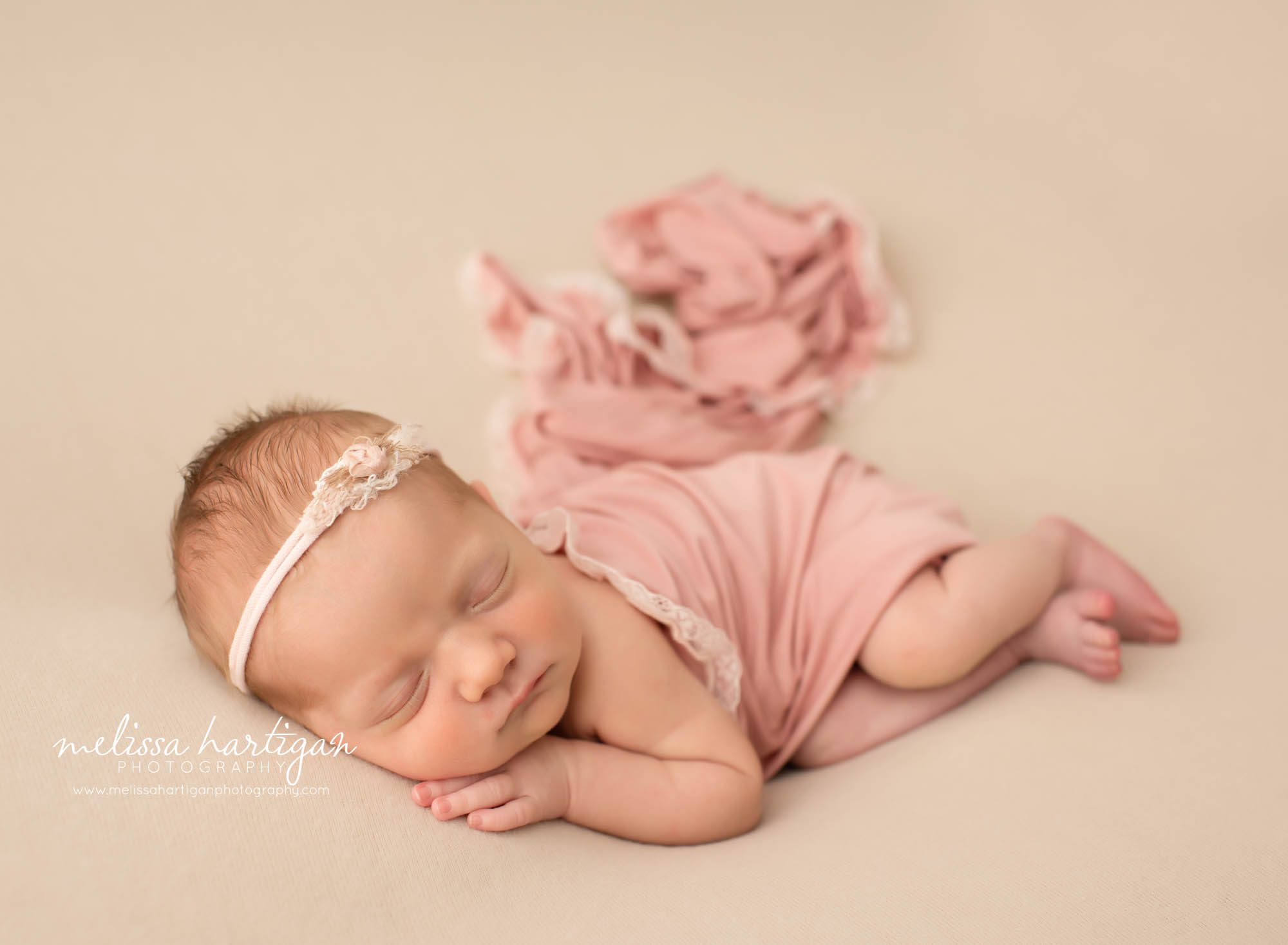 newborn baby girl posed on side with pink lace wrap and pink flower headband CT newborn photography
