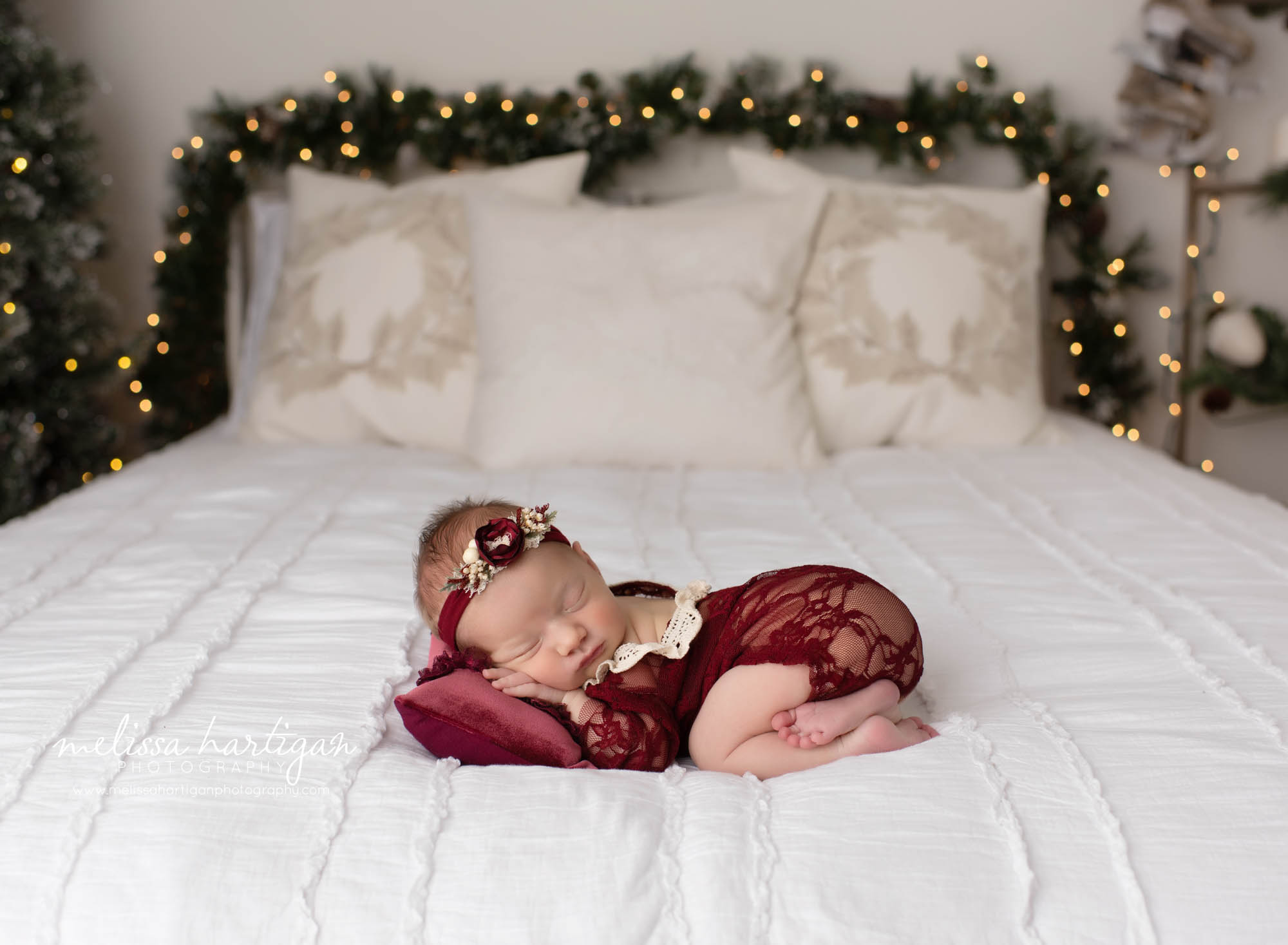 Newborn baby girl posed with bum up christmas photo setup