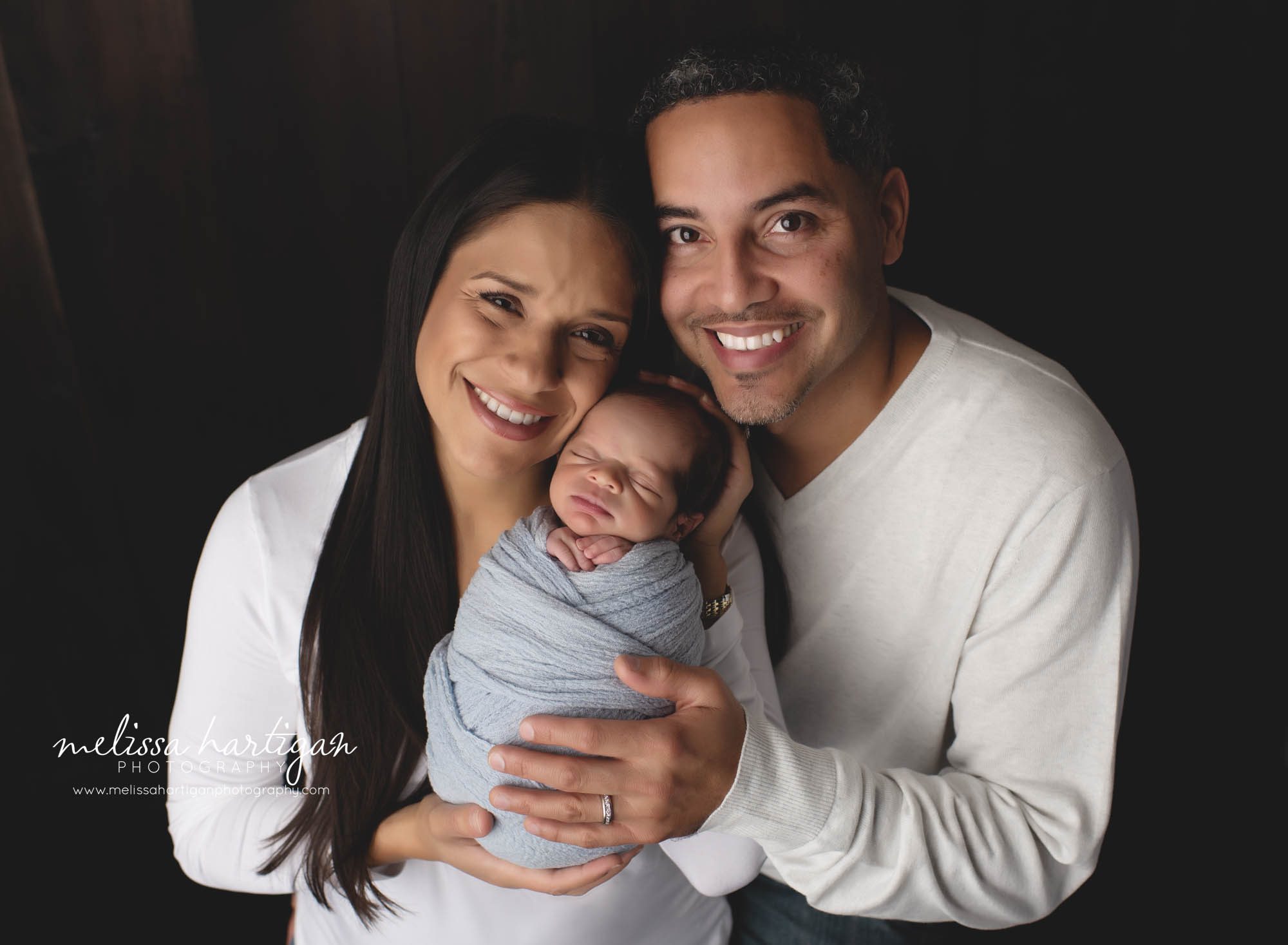 mom dad newborn son wrapped in light blue family photo newborn photography session