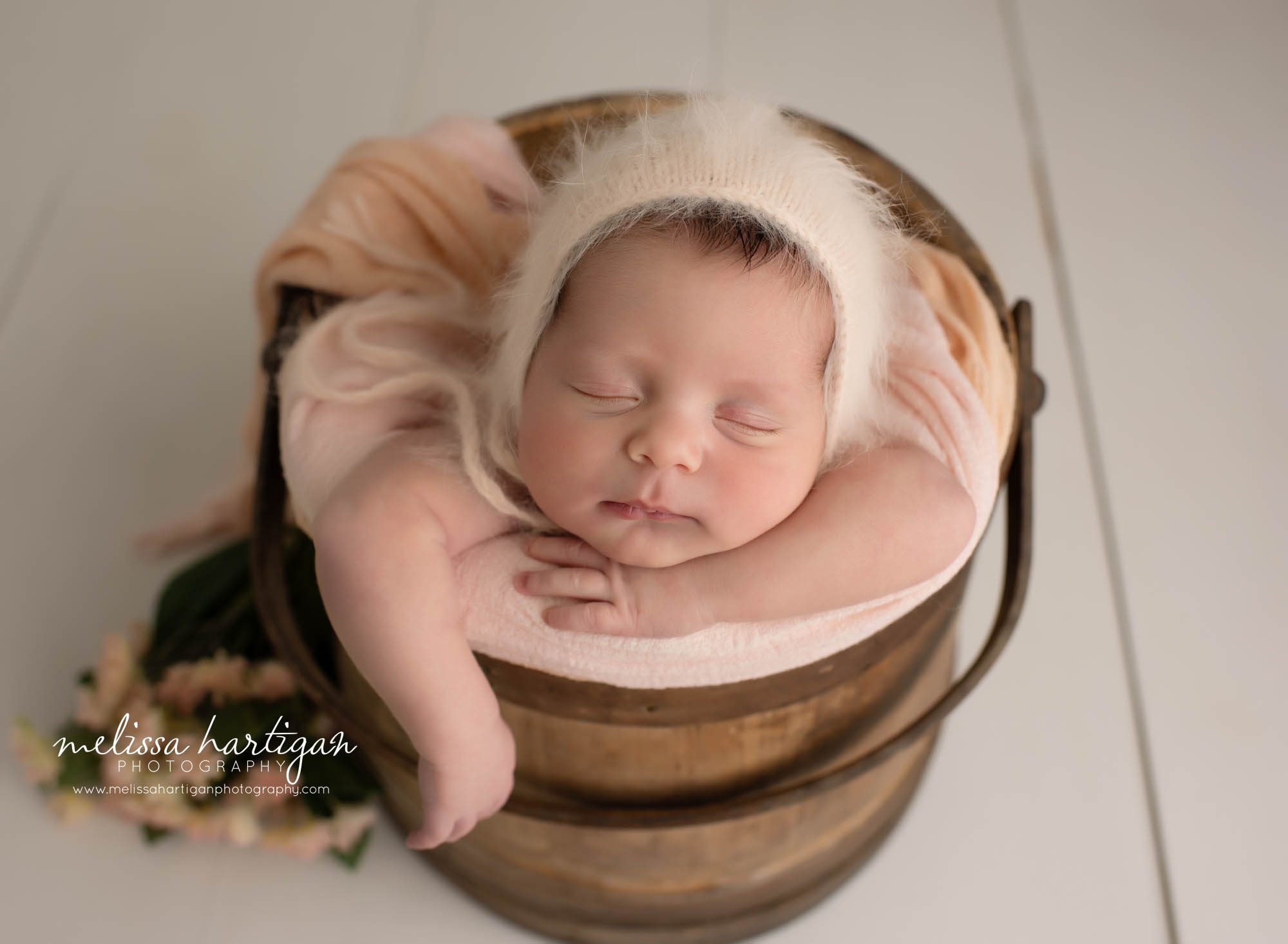 Baby girl posed in wooden bucket with blush pink tones