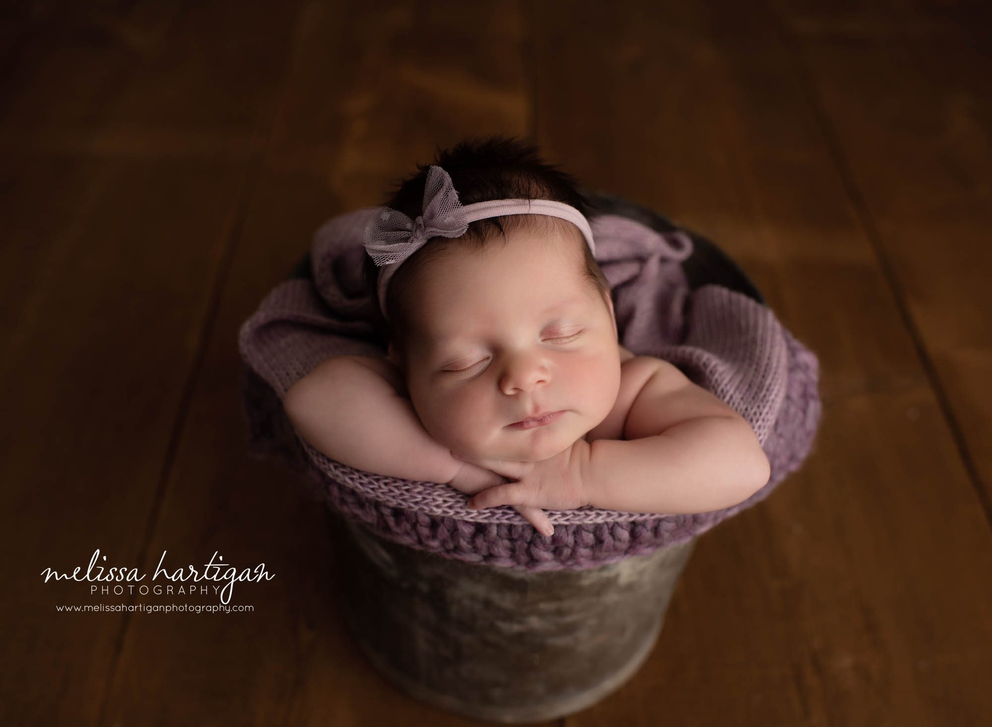 aby girl posed in wooden bucket with lavender colors newborn photography