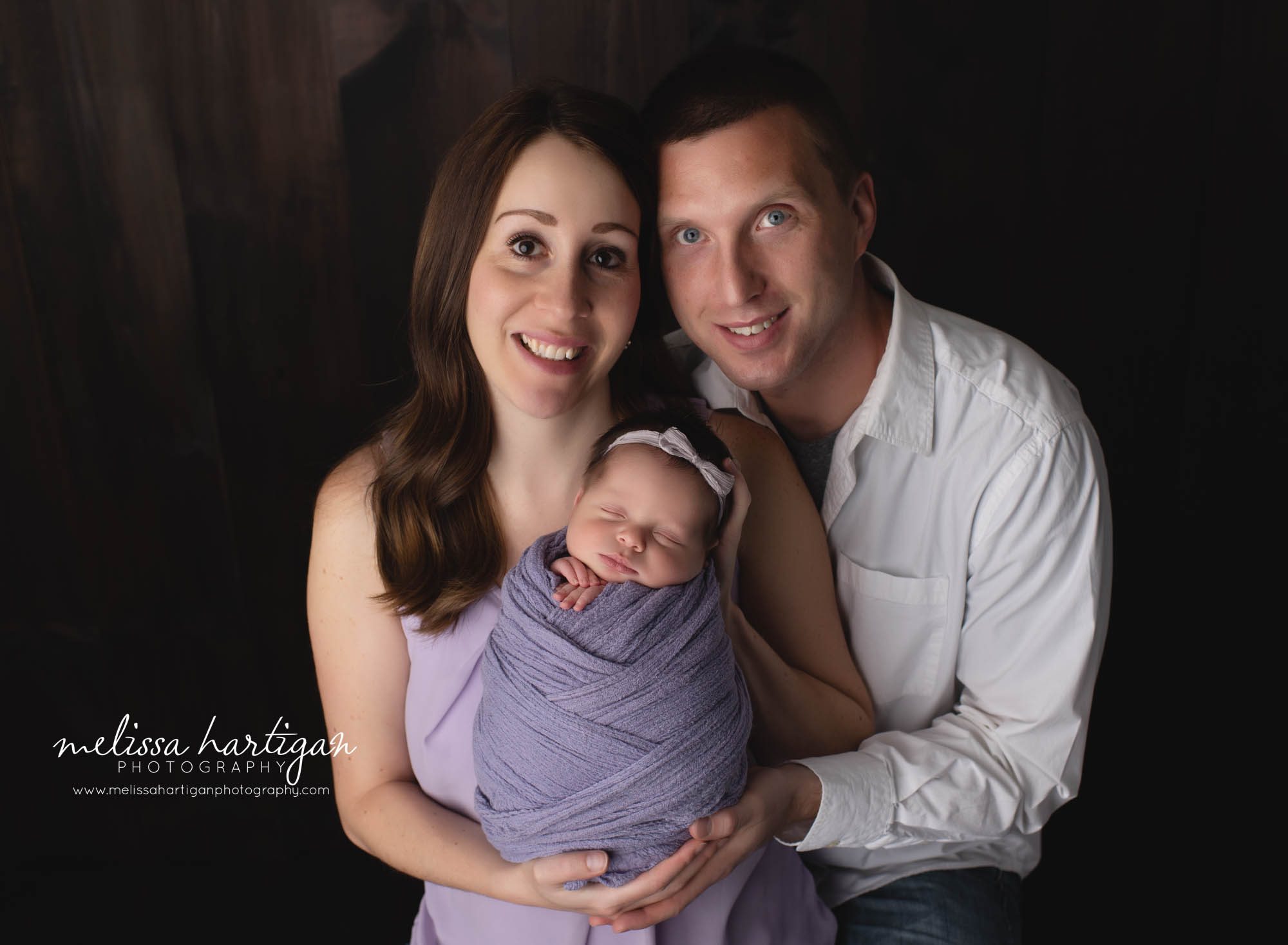 mom dad holding wrapped newborn baby girl family photos newborn session