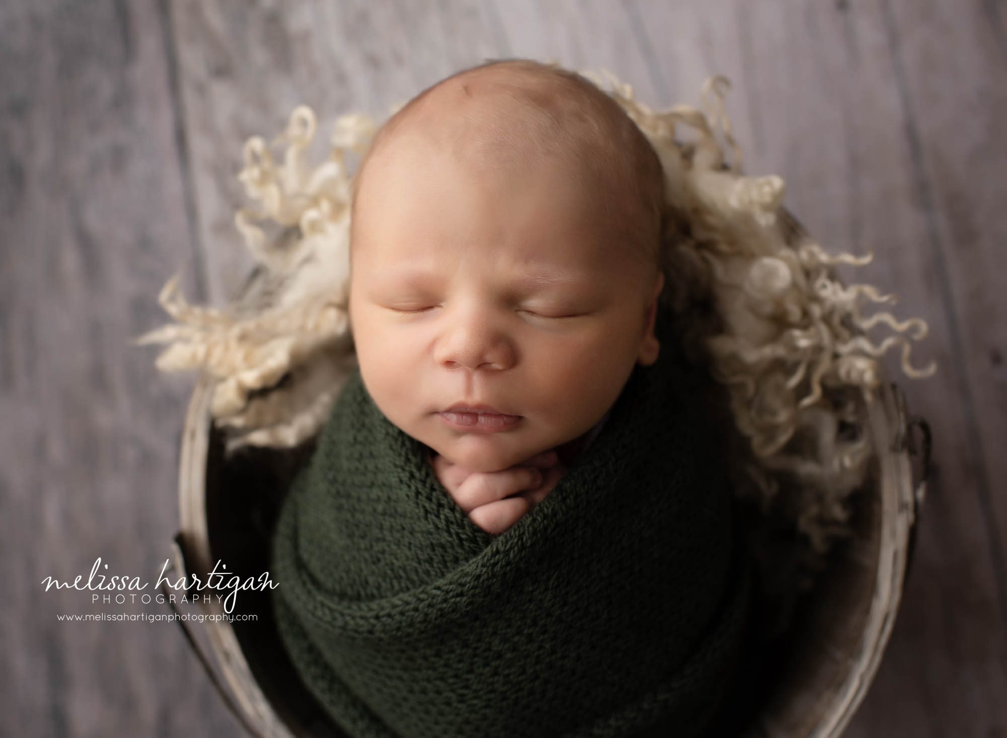 newborn baby boy wrapped in green knitted wrap New Haven County Newborn Photography
