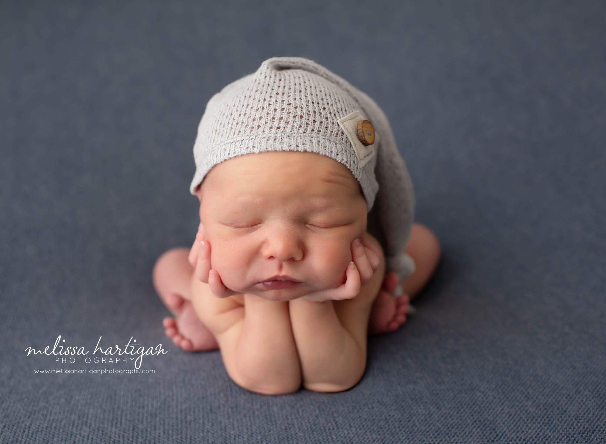 newborn baby boy posed in froggy pose with sleepy cap on Newborn Photography Tolland CT