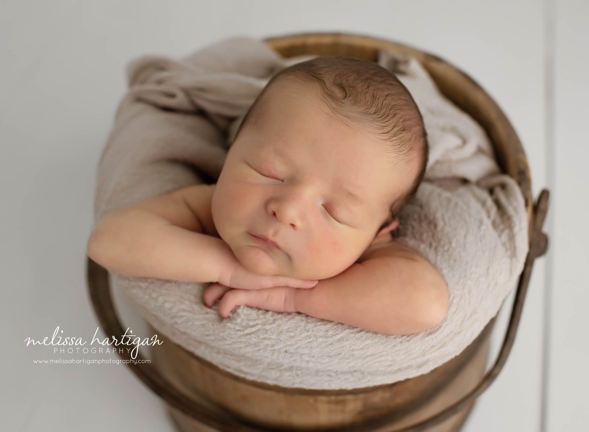 newbonr baby boy posed in wooden bucket with neutral wrap CT newborn photographer
