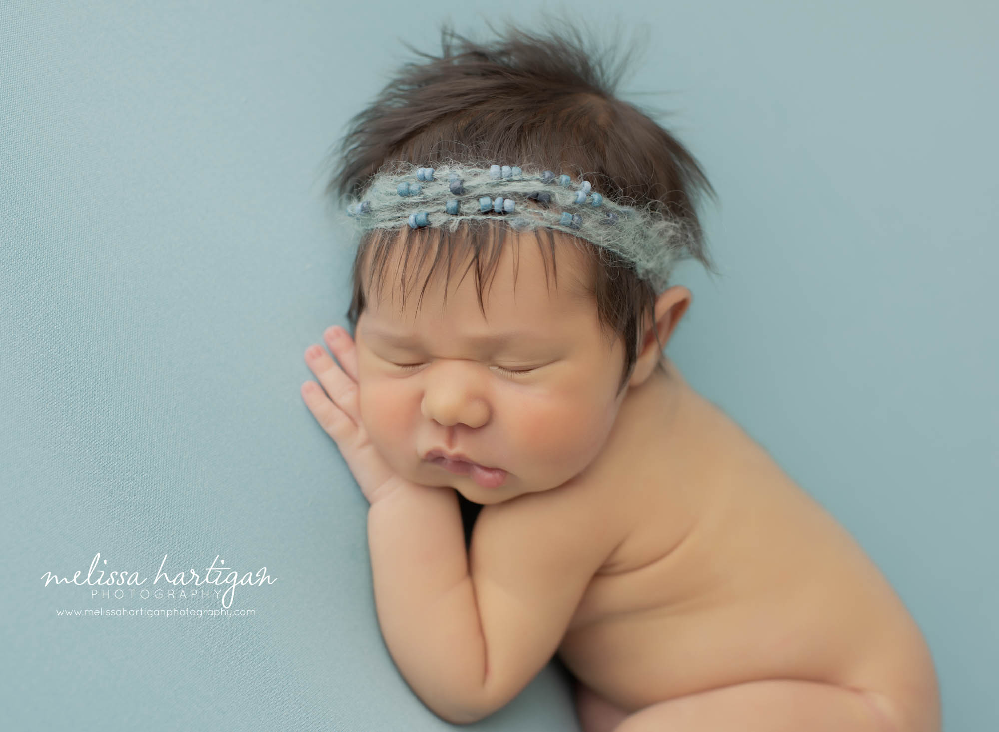 baby girl posed on side wearing beaded headband Meriden CT newborn photography