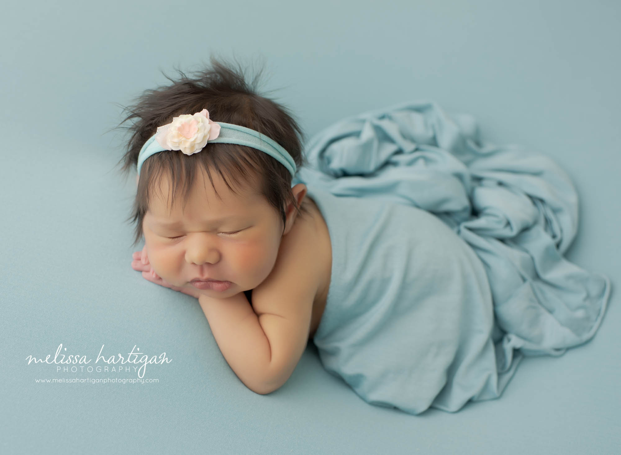 Newborn baby girl posed on side with light blue wrap draped over baby girl meriden newborn photography