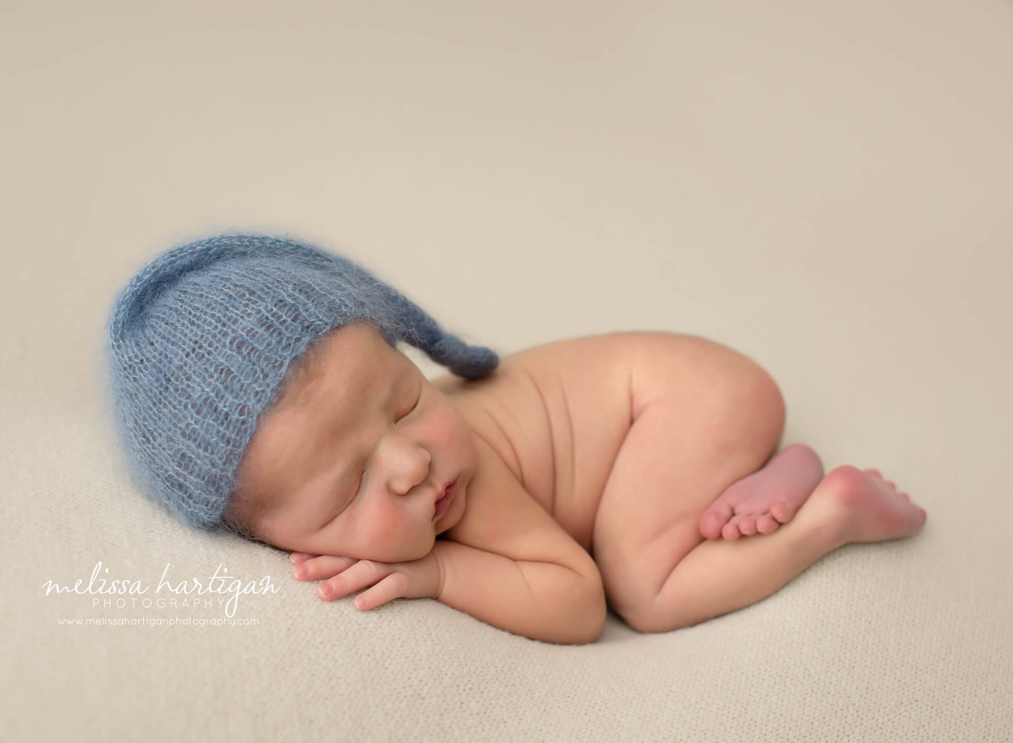newborn baby boy posed bum up pose with blue knitted sleepy cap Monroe CT Newborn Photographer