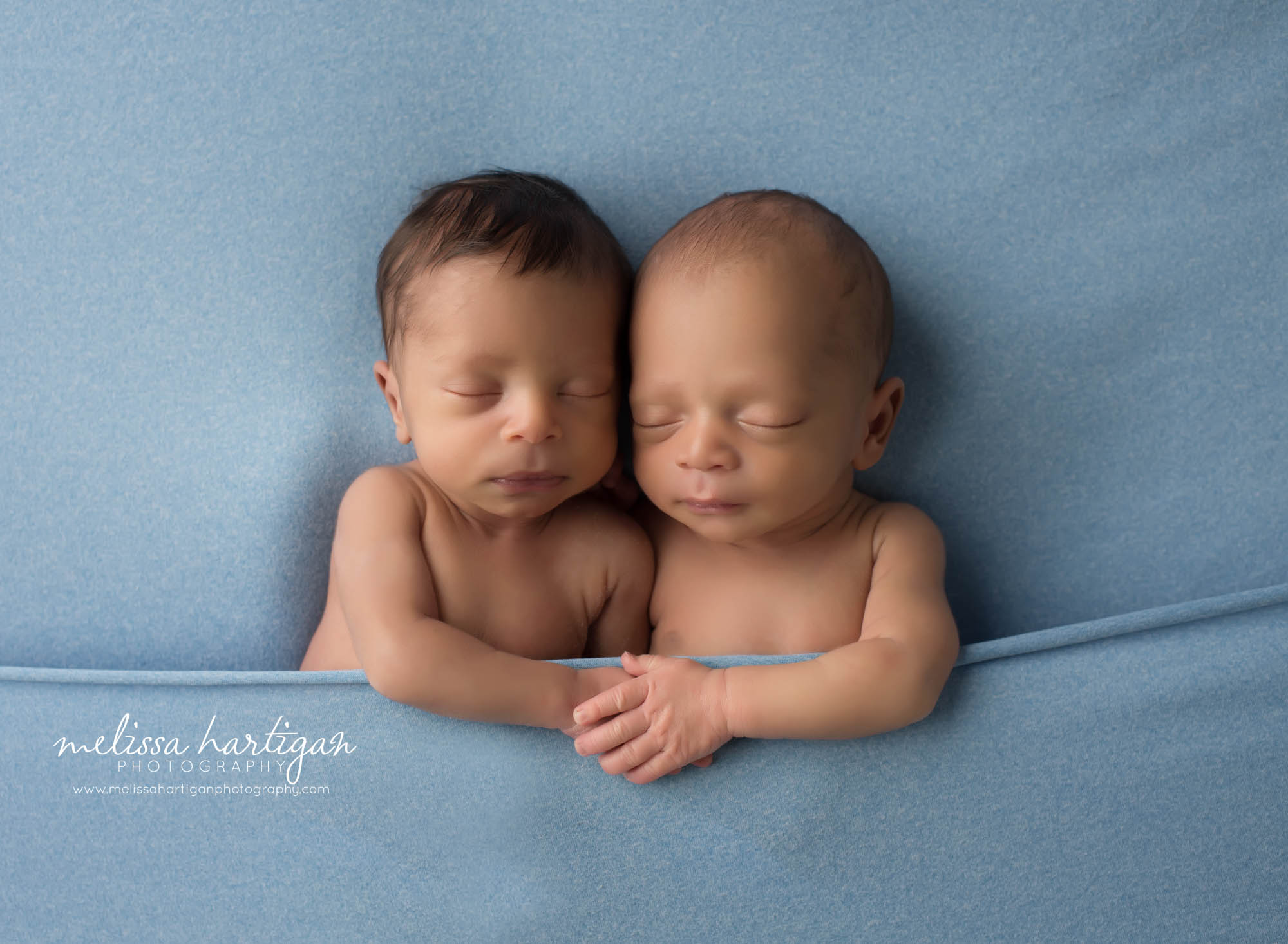 newborn baby boys posed in blue backdrop tucked in sleeping pose newborn photography CT