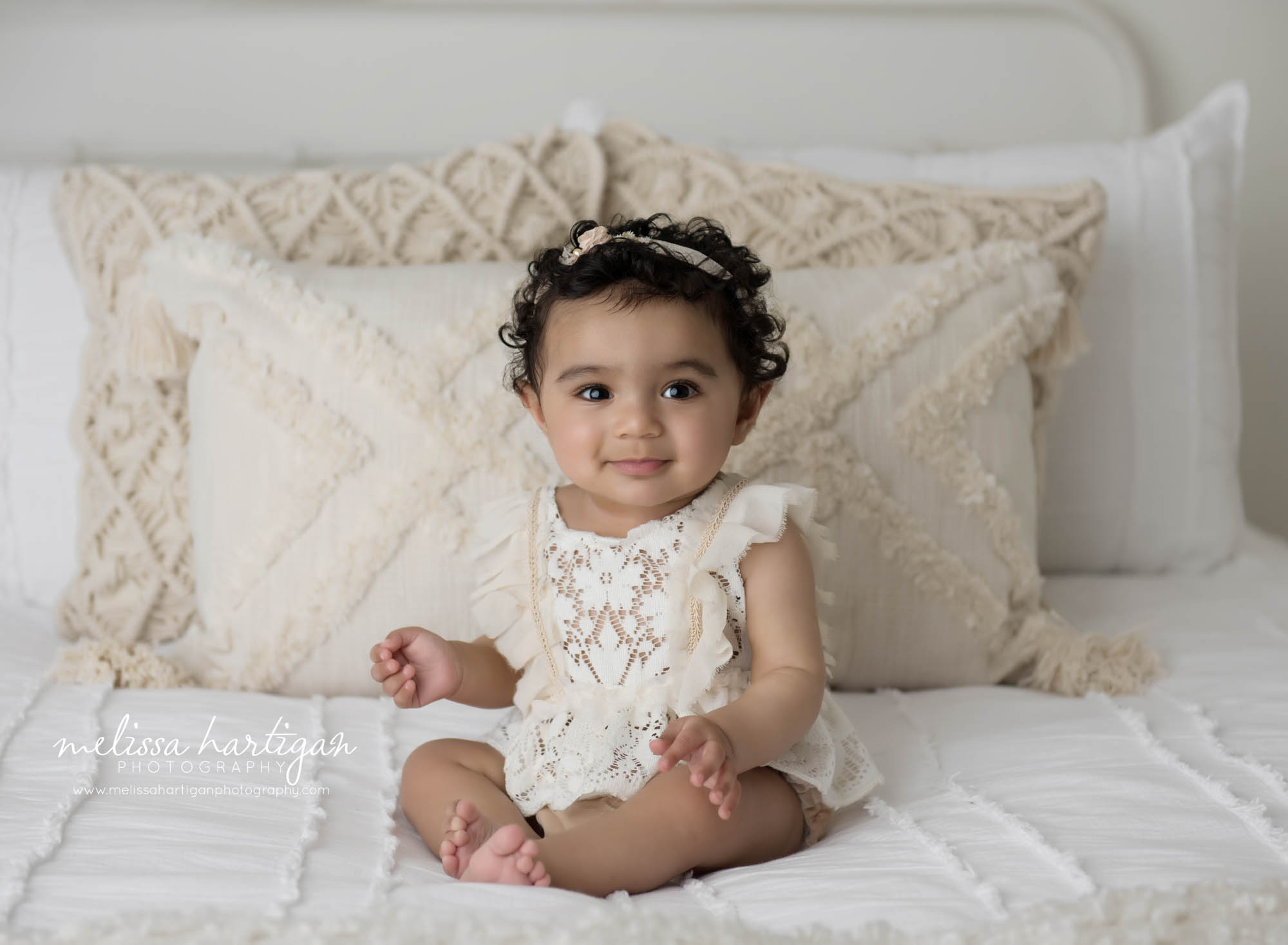 baby girl sitting on bed looking at camera baby milestone photographer CT