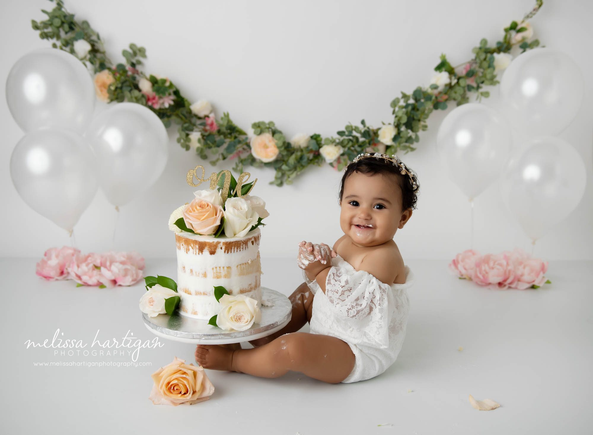 Baby girl sitting beside cake smash cake