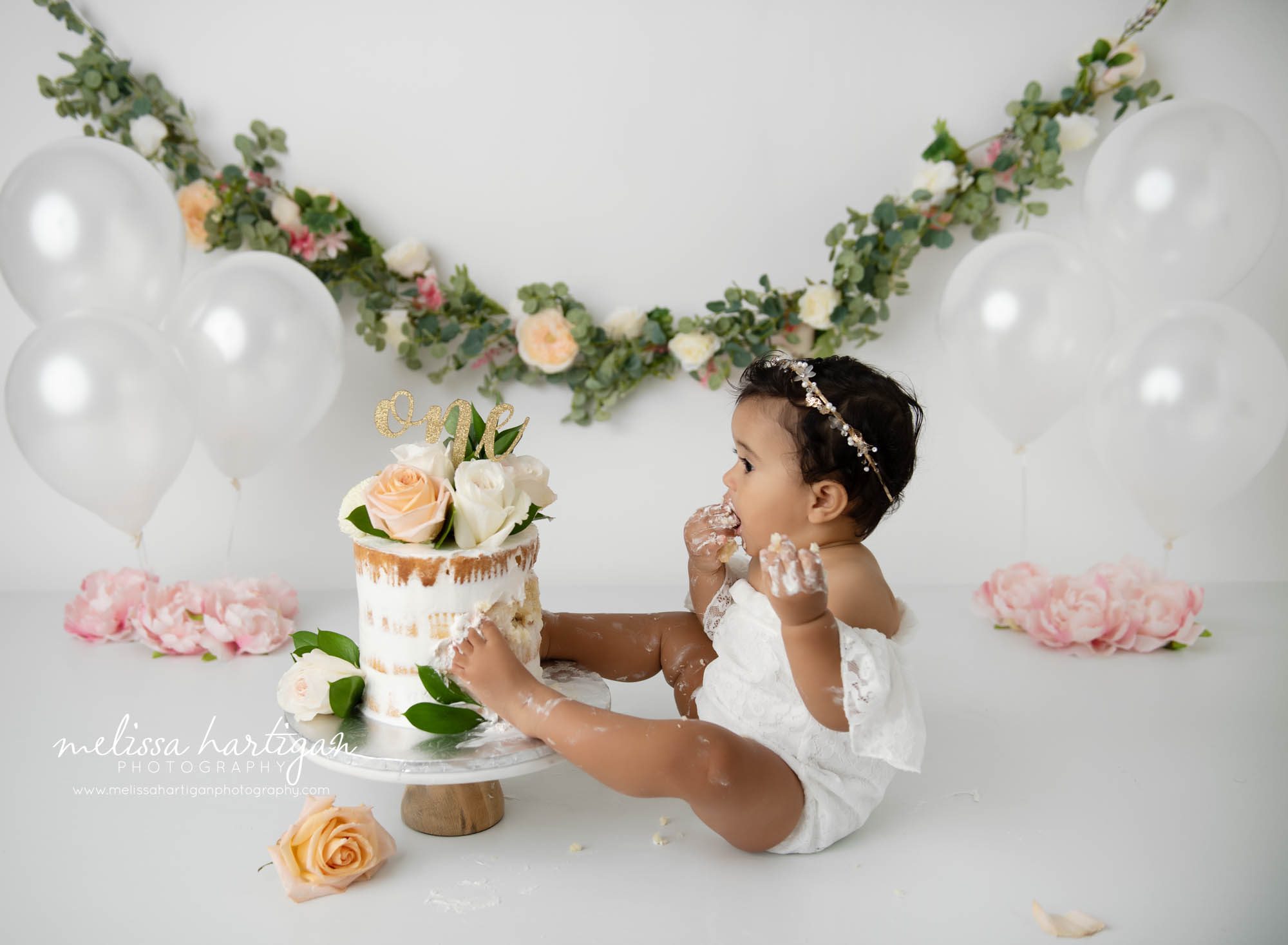 Baby girl eating cake from cake smash birthday cake