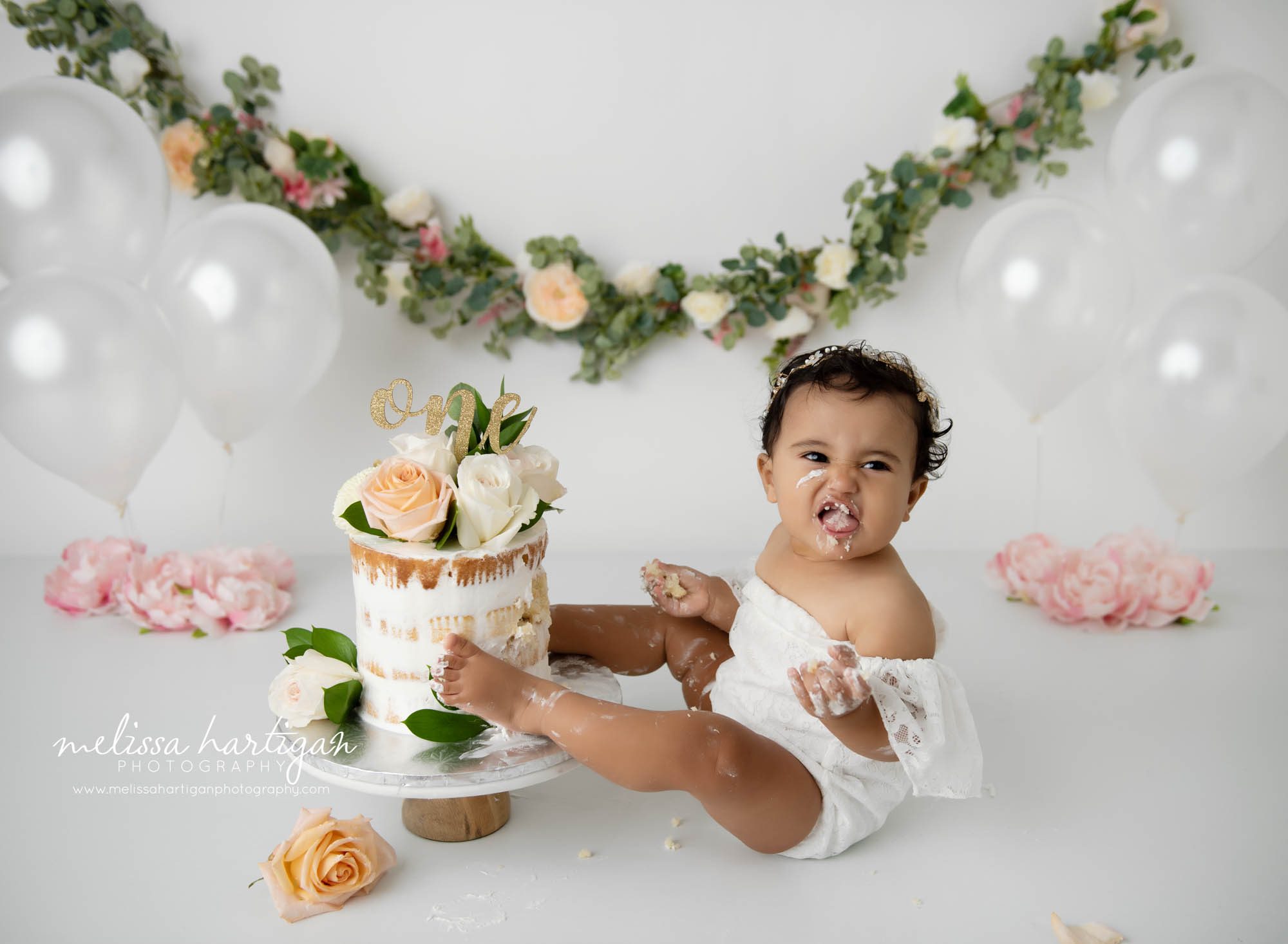 baby girl making face while eating cake smash cake