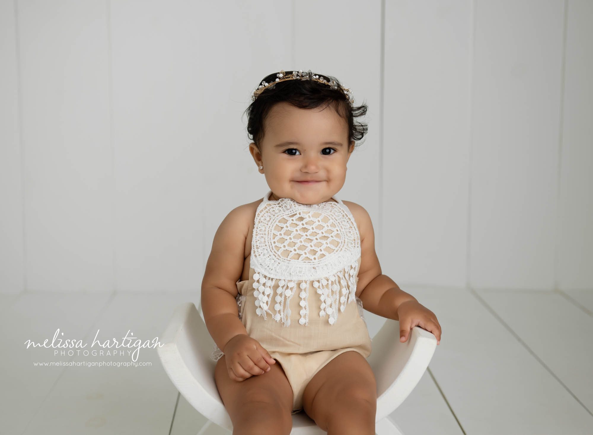 Baby girl wearing white lace outfit smiling at camera CT baby milestone photography session