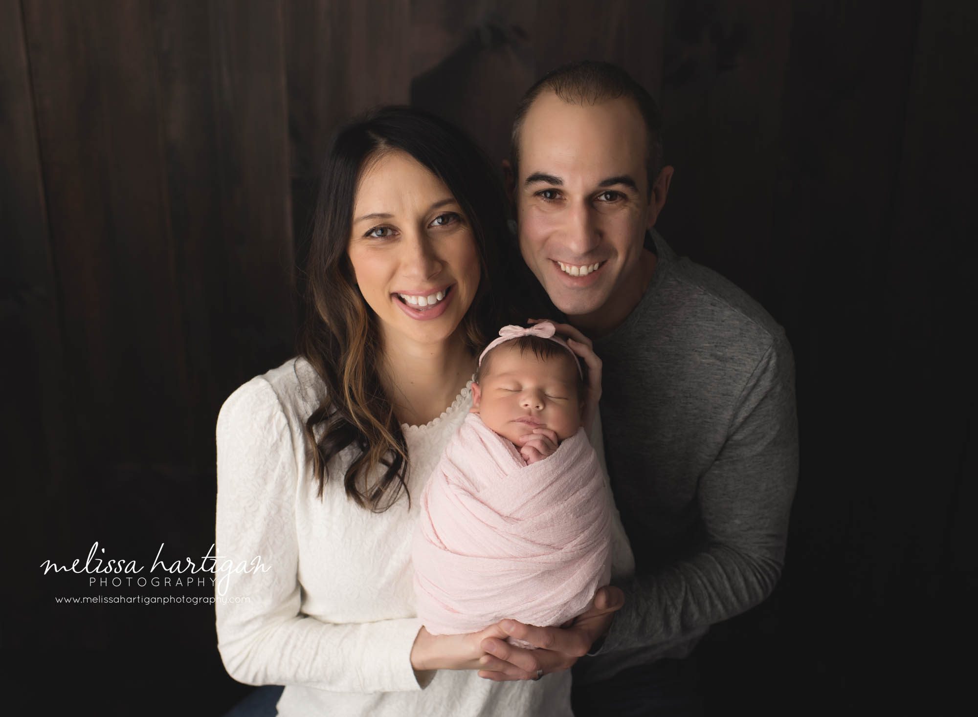 mom dad and wrapped newborn baby girl family pose newborn family photographer CT