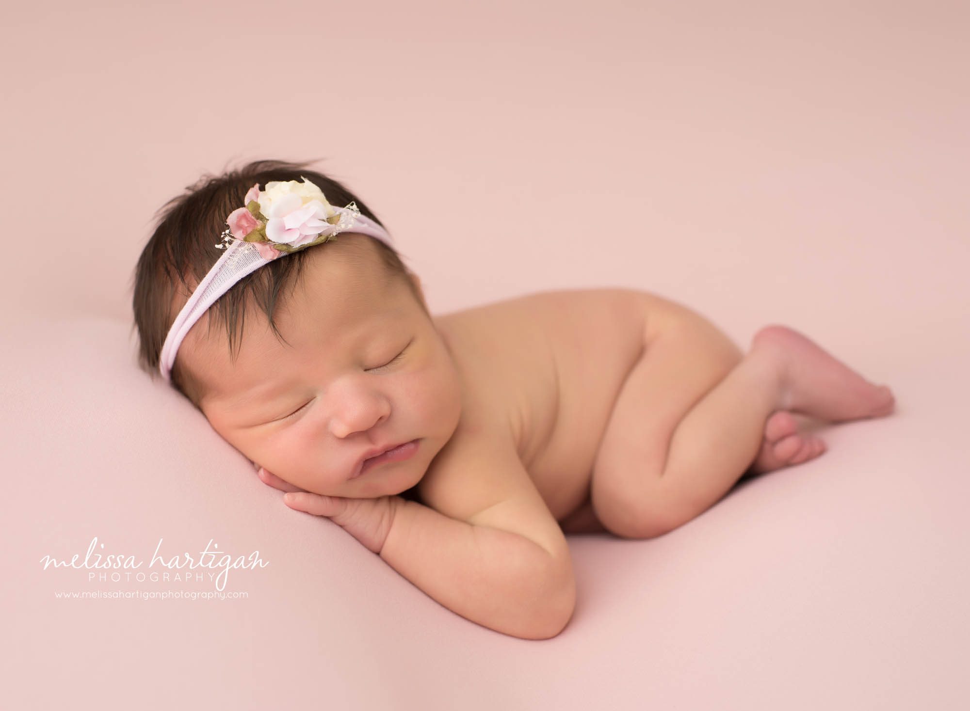 newborn baby girl posed on side with flower headband Newborn photographer CT
