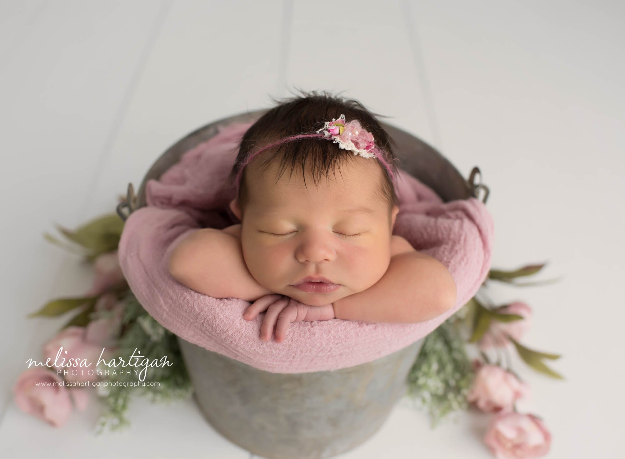 newborn baby girl posed in metal bucket with lavender layer wrpa and headband Newborn photography CT south glastonbury
