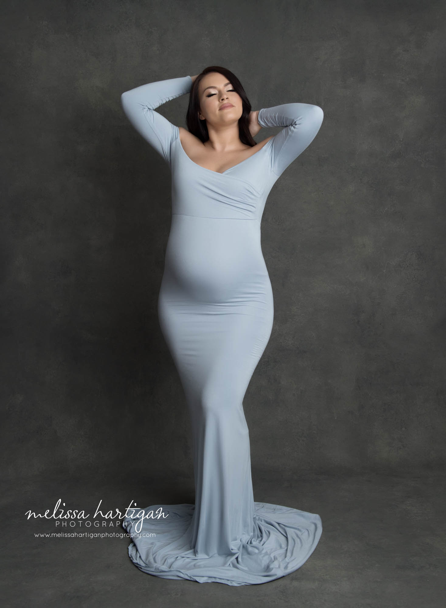 pregnant mom wearing blue form fitted long maternity dress pregnancy pose