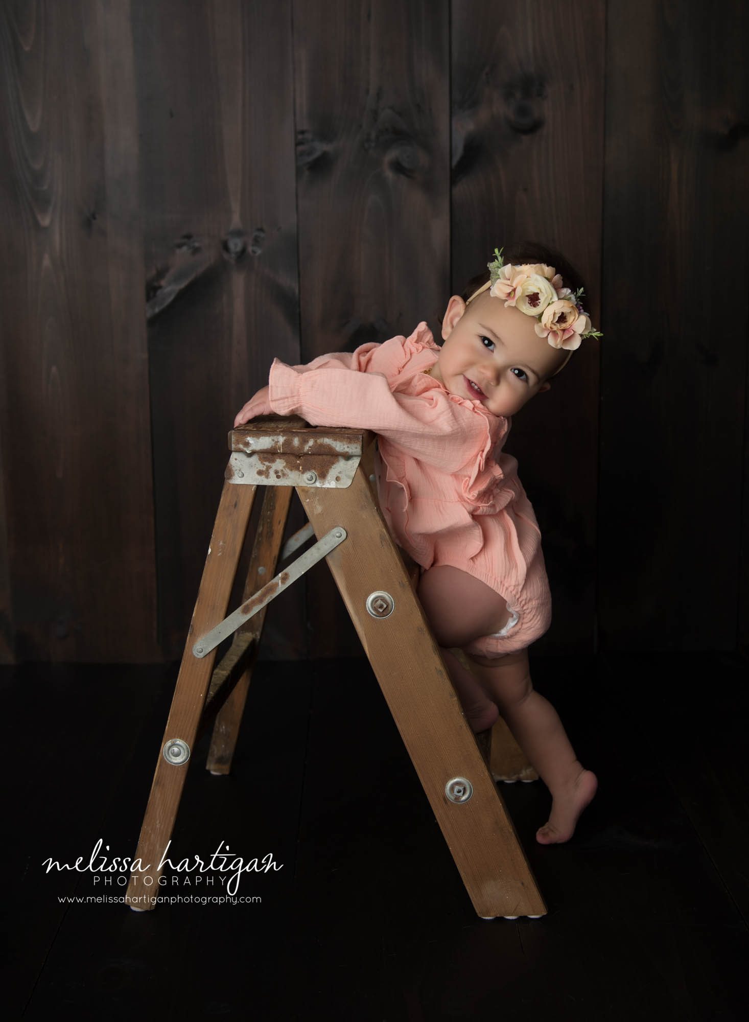 baby girl climbing short wooden step ladder studio milestone session