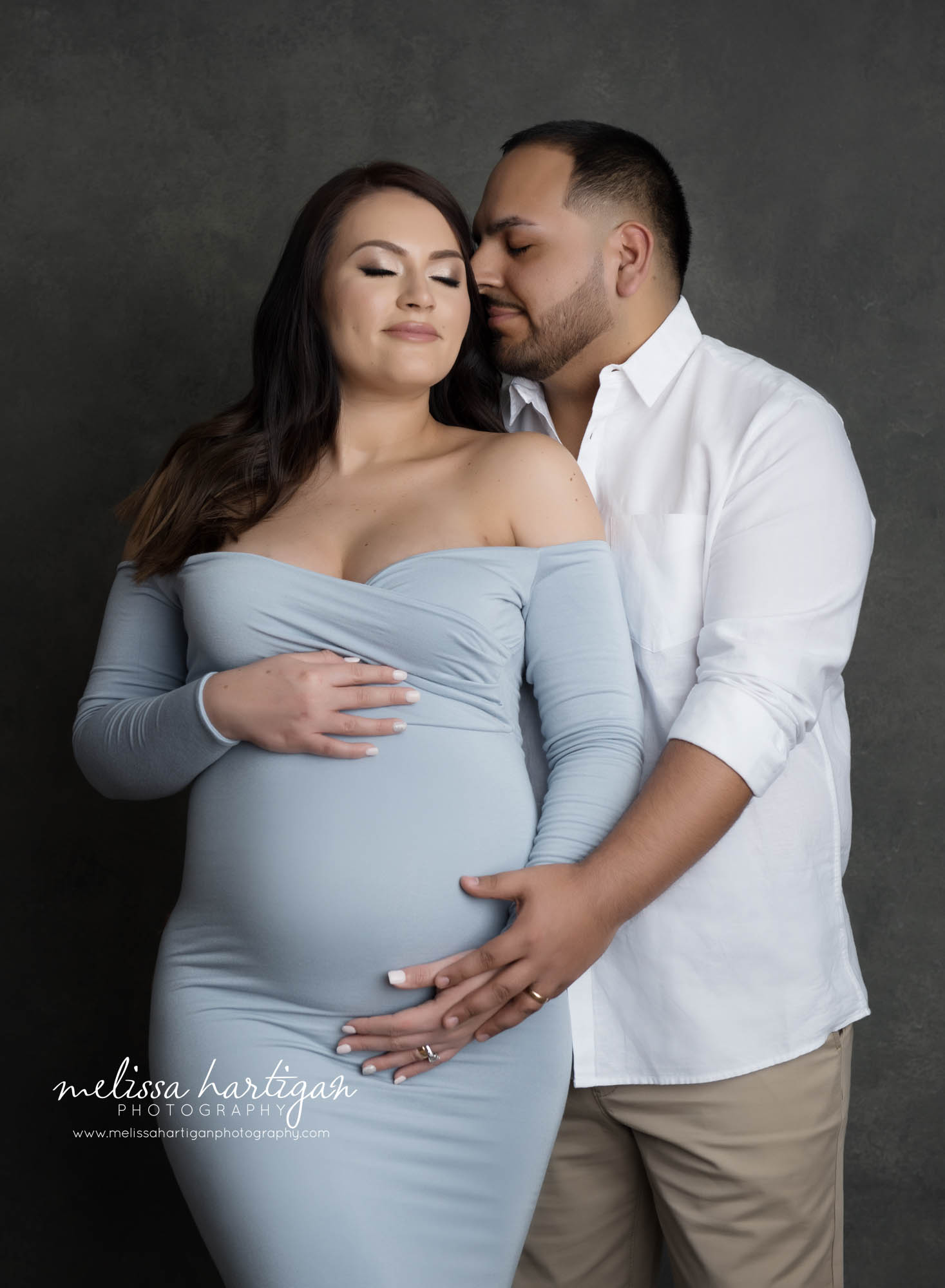 expectant couple holding baby bump in studio maternity couples pose CT maternity photography