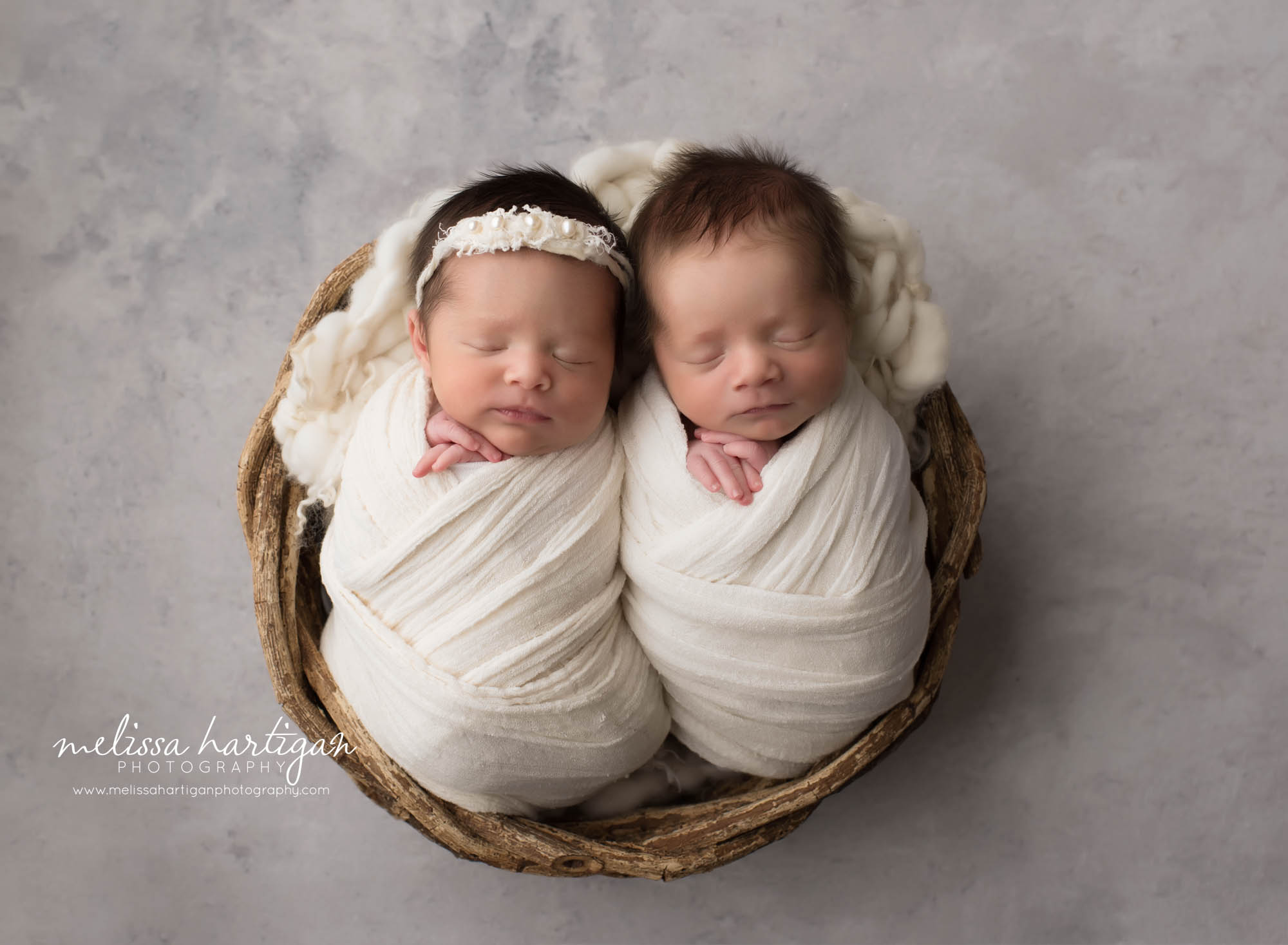 boy girl twin babies wrapped in cream wraps and posed beside each other in wicker basket with cream layer newborn photographer CT