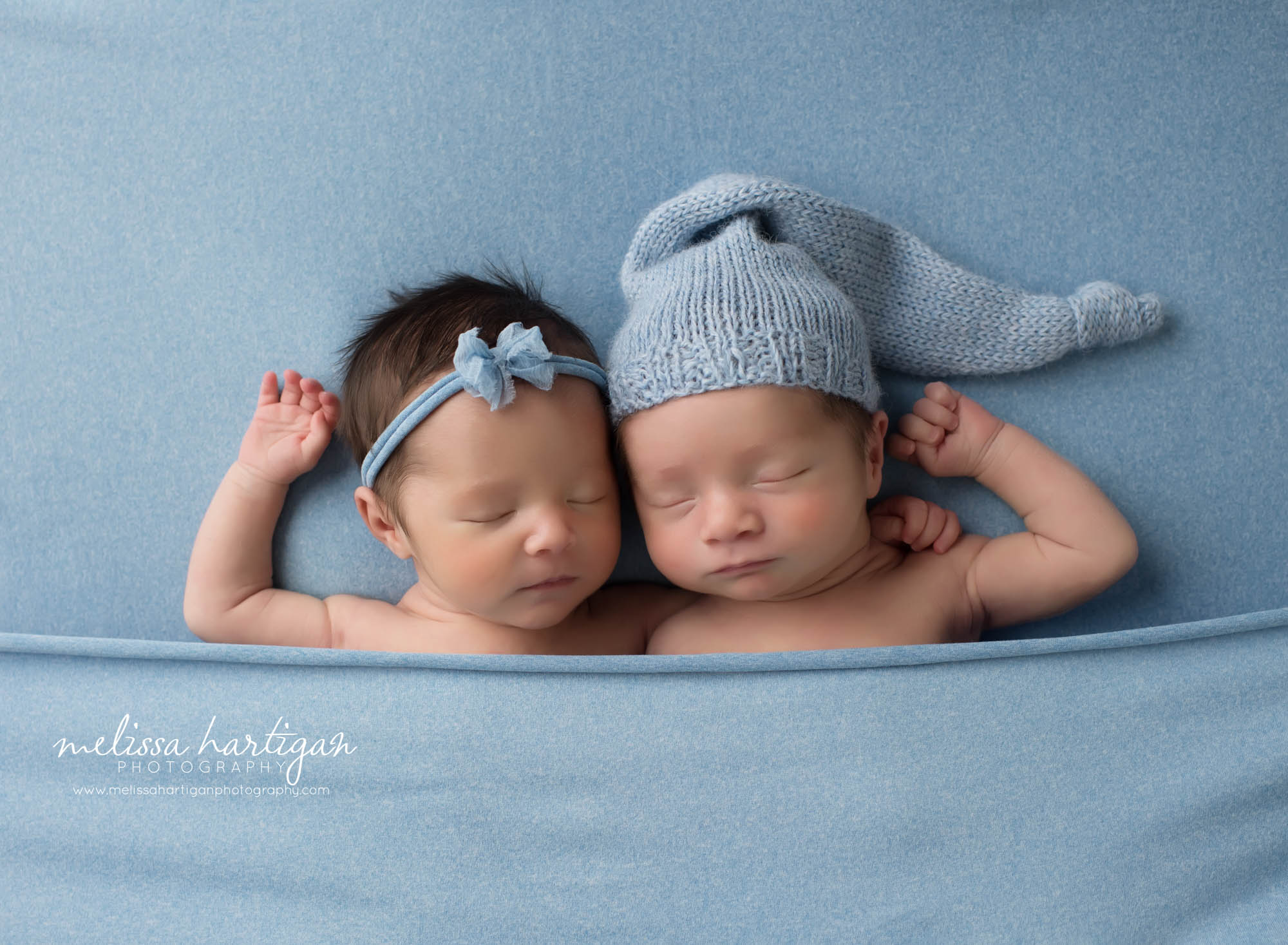 boy girl twin babies posed beside each other tucked in on blue blanket newborn photography CT