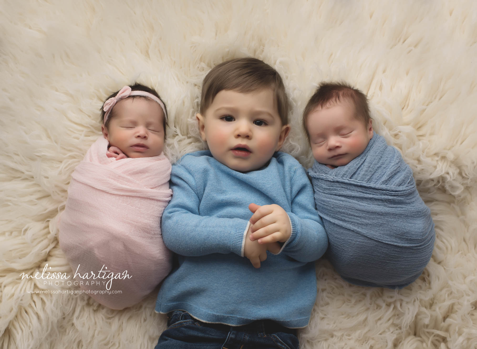 twin baby girl and twin baby boy wrapped up laying beside toddler big brother sibling photo pose