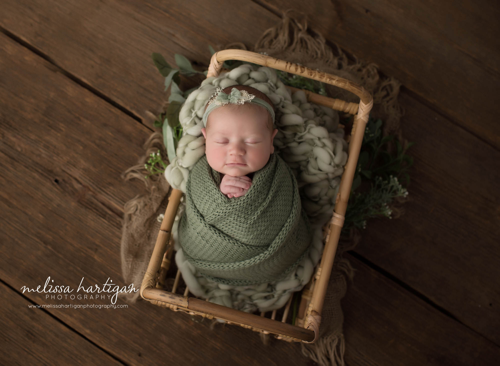 newborn baby girl wrapped in green posed in wicker basket CT newborn Photographer