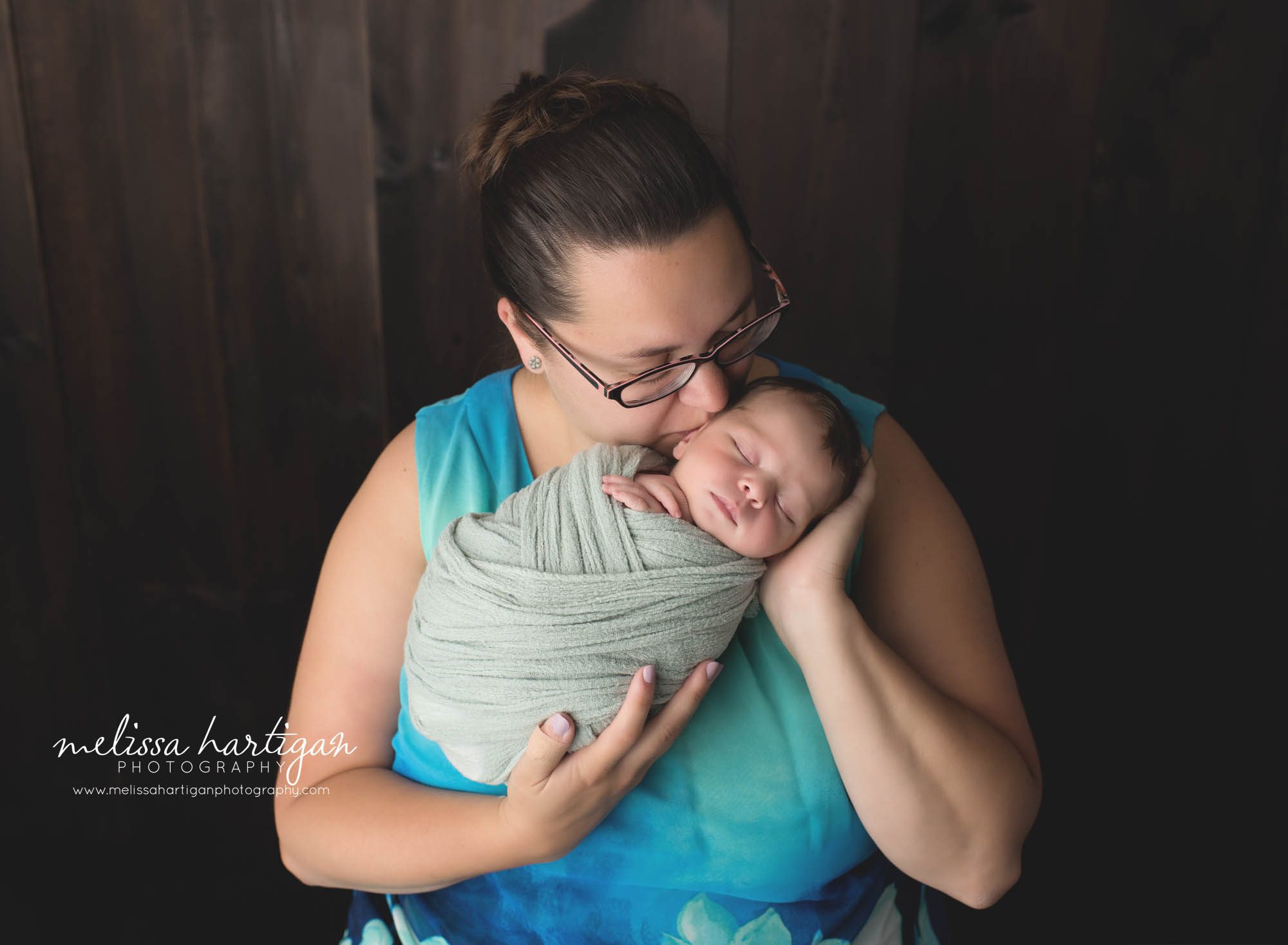 mom kissing newborn son on side of face mom and baby pose