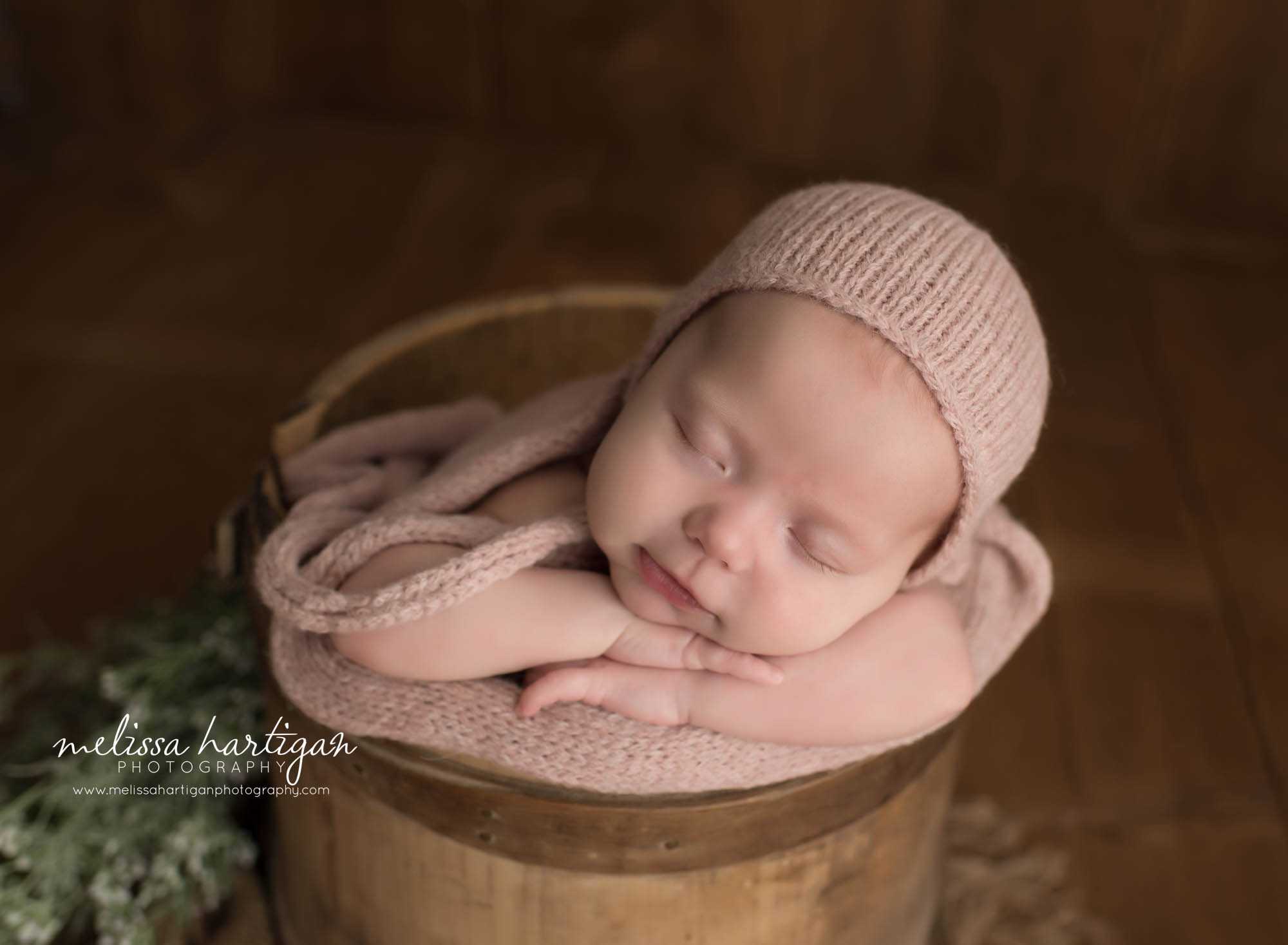 newborn baby girl posed and sleeping on crossed arms