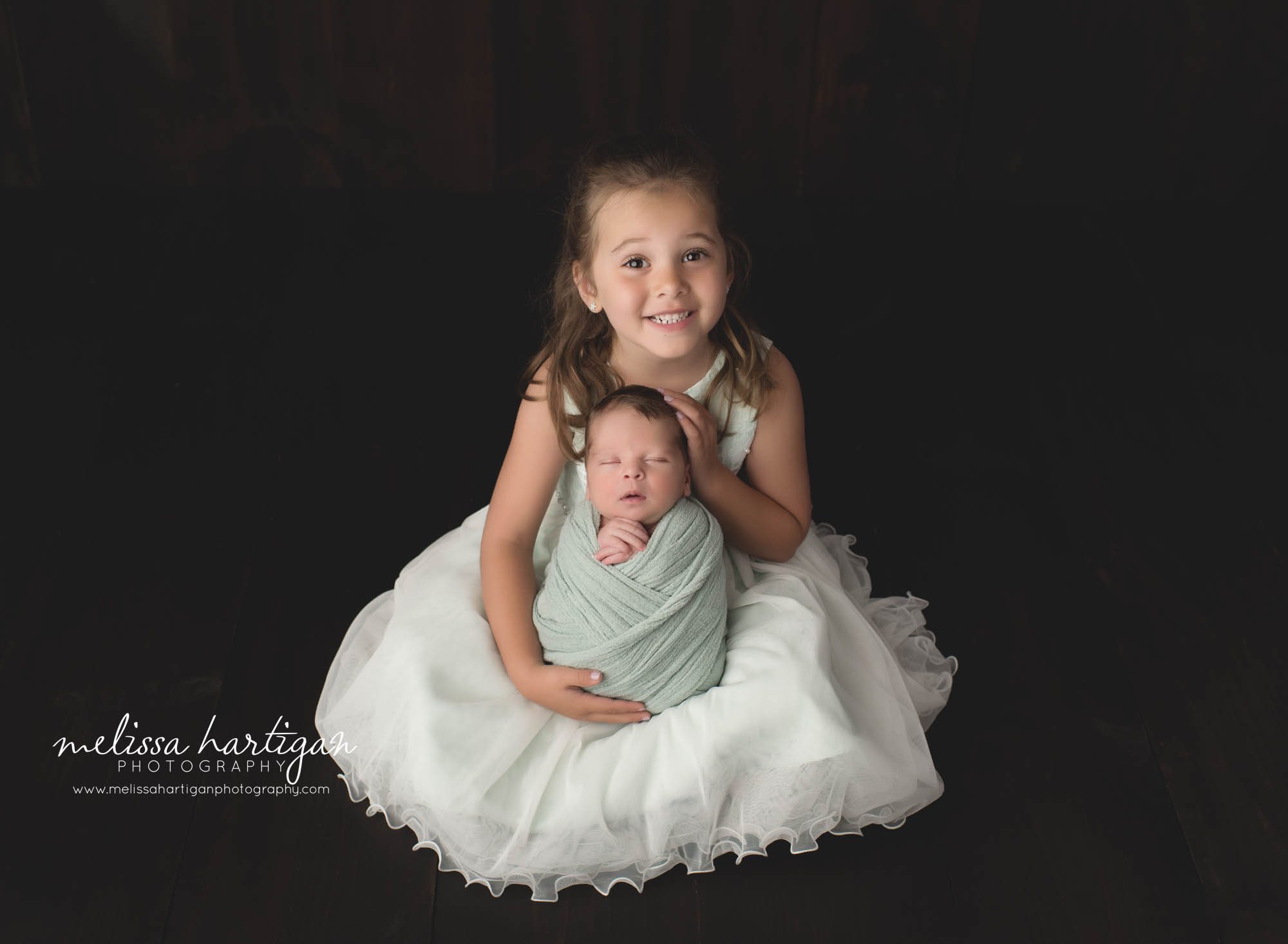 big sister holding baby brother studio newborn photography session