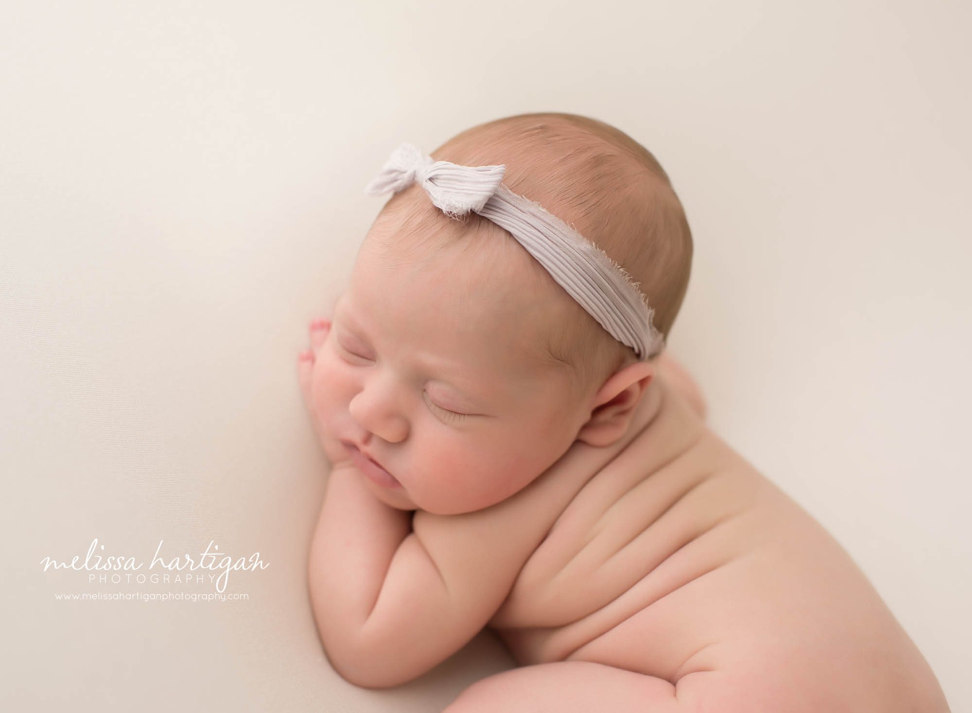baby girl posed on side with back rolls in newborn photography CT session