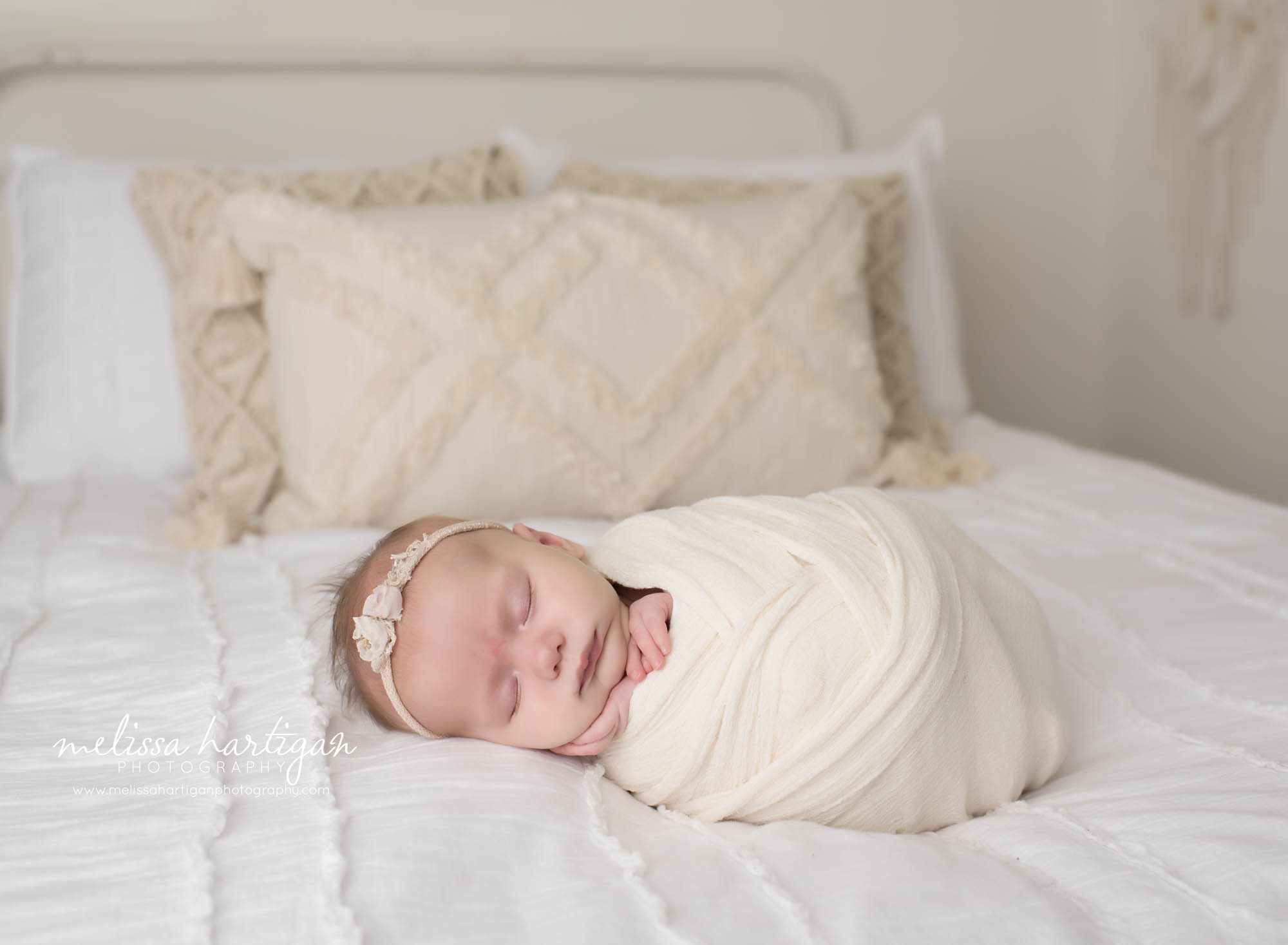 wrapped newborn baby girl posed in studio bed as prop