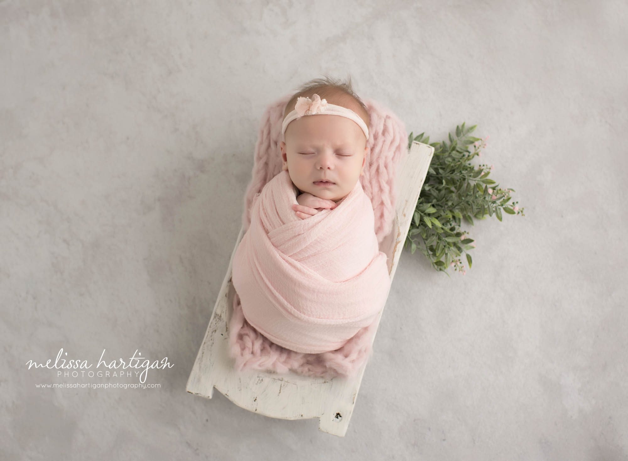 newborn baby girl wrapped in soft baby pink wrap with pink layer and greenery Windsrot CT Newborn Photography