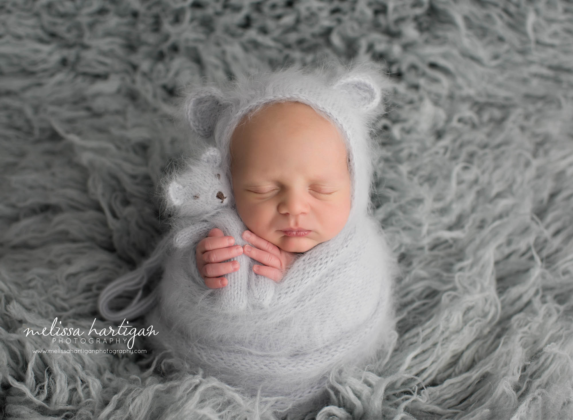 newborn baby boy wrapped in gray knitted wrap with light gray knitted bear bonnet and matching knitted teddy bear angora CT newborn photographer