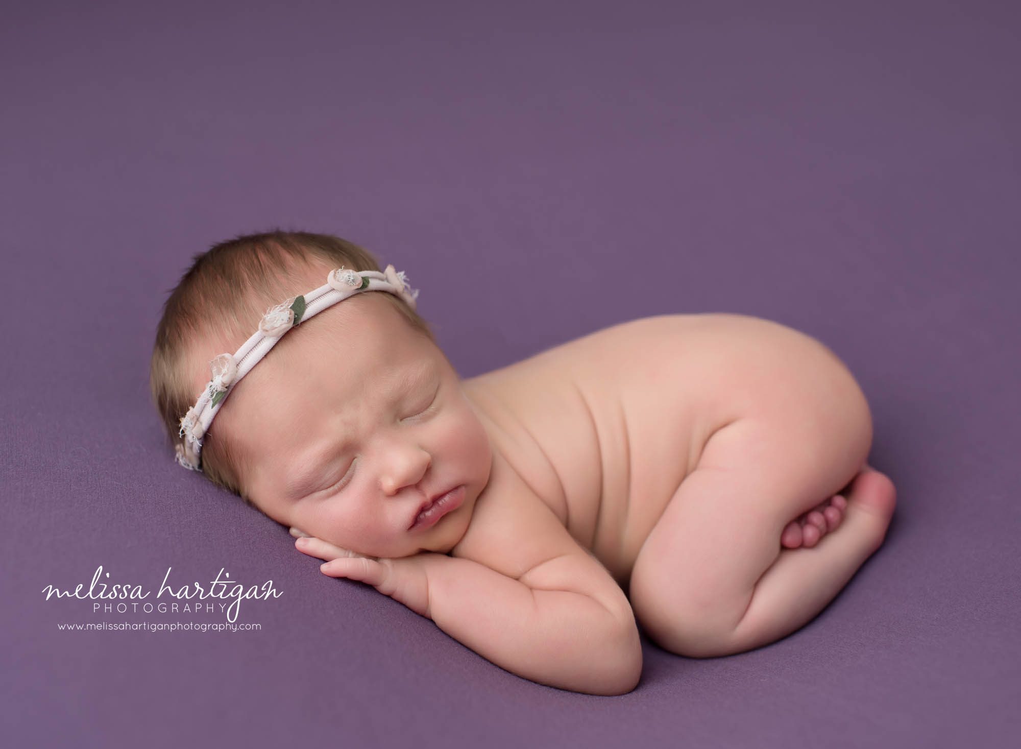 Newborn baby girl posed on tummy with flower headband Ct newborn photographer